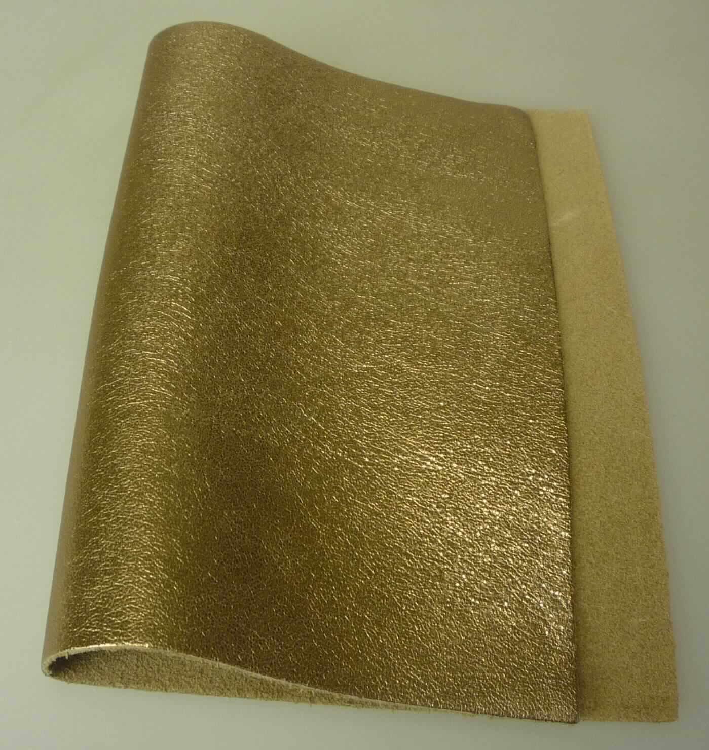 Metallisiertes Leder, sog. Kalbhälfte, Narbenspalt, Foto siehe Anlage,
- aus Leder vom Kalb (laut Antrag),
- enthaart und gegerbt,
- auf einer Seite mit einem metallisierten, bronzefarbenen Farbaufstrich versehen.

"Metallisiertes Leder"