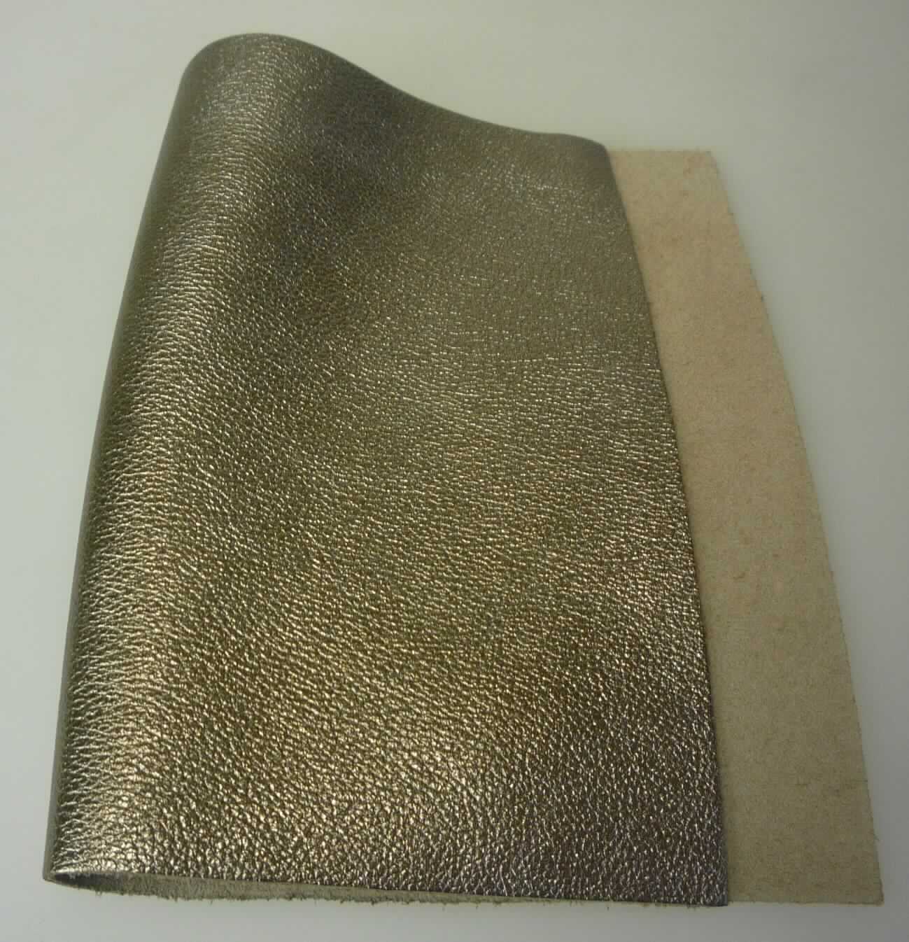 Metallisiertes Leder, sog. Kalbhälfte, Narbenspalt, Foto siehe Anlage,
- aus Leder vom Kalb (laut Antrag),
- enthaart und gegerbt,
- auf einer Seite mit einem metallisierten, goldfarbenen Farbaufstrich versehen.

"Metallisiertes Leder"