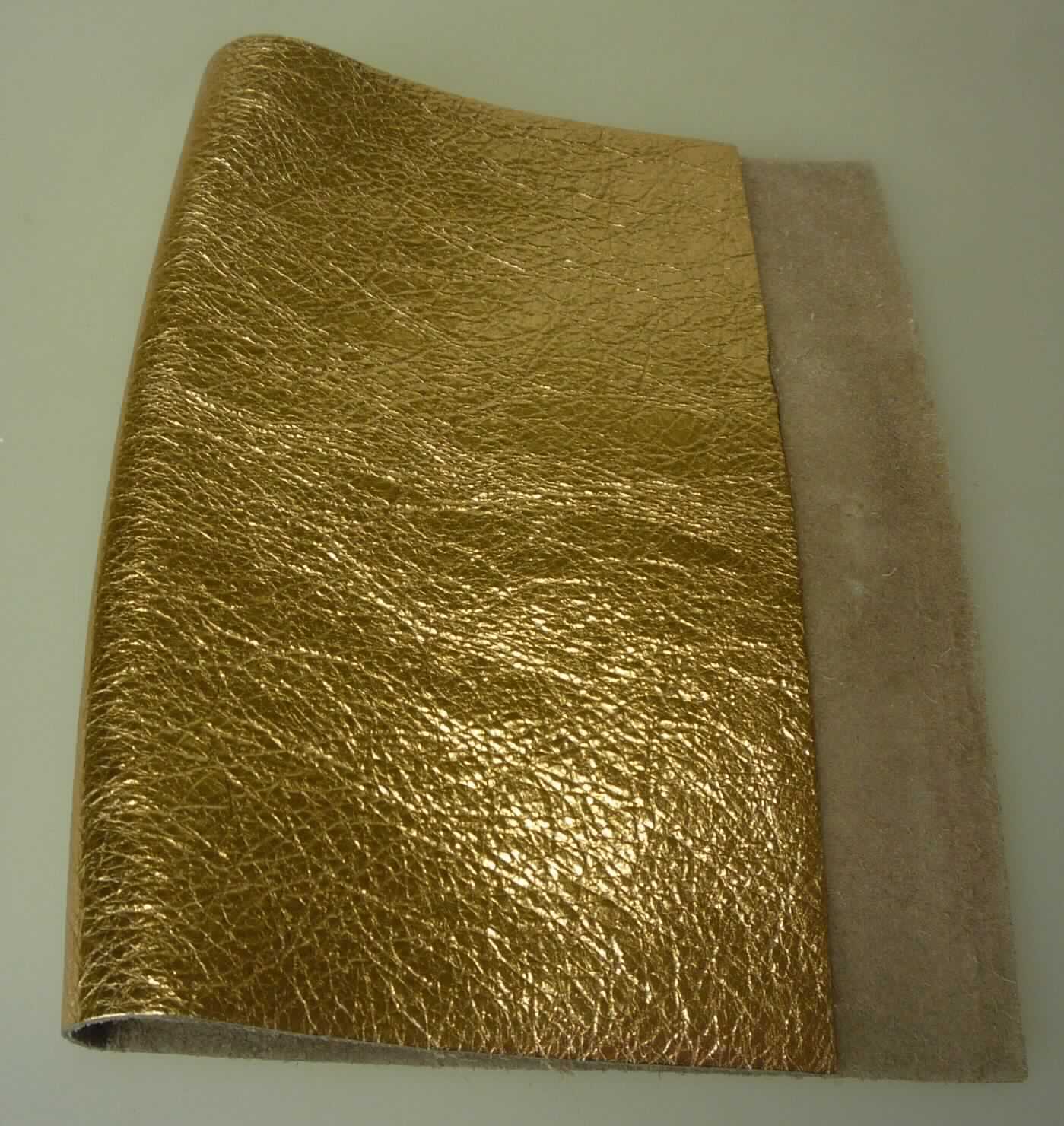 Metallisiertes Leder, sog. Kalbhälfte, Narbenspalt, Foto siehe Anlage,
- aus Leder vom Kalb (laut Antrag),
- enthaart und gegerbt,
- auf einer Seite mit einem metallisierten, bronzefarbenen Farbaufstrich versehen.

"Metallisiertes Leder"