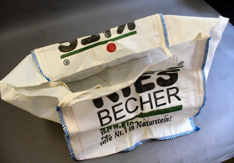Sack zu Verpackungszwecken, sog. flexibler Schüttgutbehälter, Fotos siehe Anlage,
- quaderförmig; in den Abmessungen von: etwa 90 cm x 90 cm x 87 cm,
- aus Geweben aus Streifen aus laut Antrag Polypropylen (synthetische Spinnmasse) mit einer
  augenscheinlichen Breite von weniger als 5 mm; ein beidseitiges Überziehen oder Bestreichen mit
  Kunststoff ist mit bloßem Auge nicht wahrnehmbar, somit keine Ware des Kapitels 39,
- an allen Ecken mit Aufhängeschlaufen versehen,
- mit großflächigem Firmenaufdruck auf der Vorderseite,
- durch Zusammennähen konfektioniert,
- dient dem Transport verschiedener Güter mit einem Fassungsvermögen von lt. ergänzenden Antragsangaben
  bis zu 1000 kg.

"Sack zu Verpackungszwecken, aus synthetischen Spinnstoffen, flexibler Schüttgutbehälter,
 aus Streifen aus Polypropylen, aus Geweben"