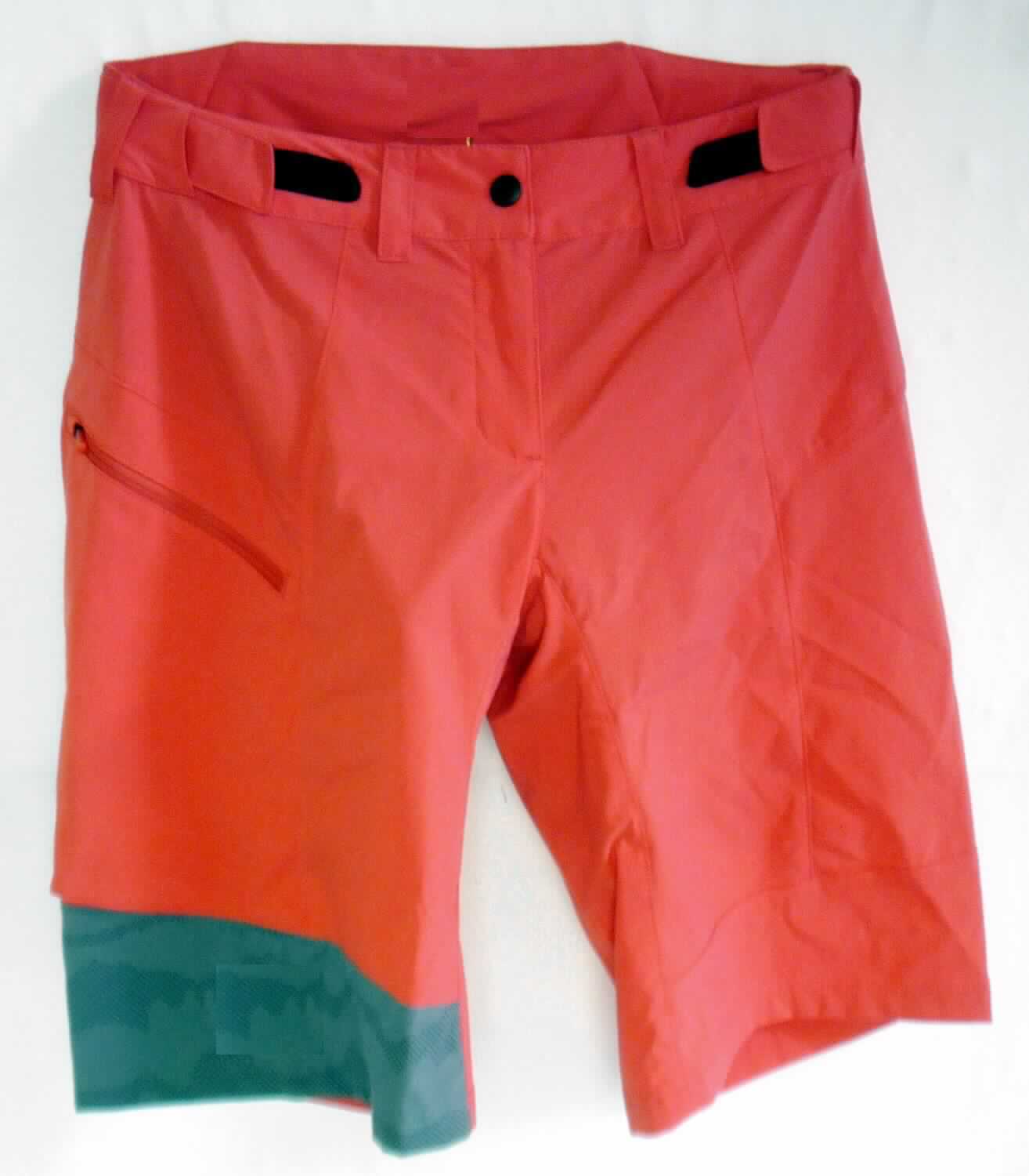 Kurze Hose, sog. Shorts, Art. 421951, Größe XS, Foto siehe Anlage,
- in einem Polybeutel verpackt,
- aus verschiedenen, ca. 0,4 mm dicken, einfarbigen und maschinell bedruckten Geweben aus laut Antrag
  94 % Polyamid und 6 % Elasthan (beides synthetische Chemiefasern),
- in der Taille abschließend; mit einem ca. 4,5 cm breiten, angesetzten Taillenbund mit Gürtelschlaufen; mit seitlich
  angesetzten, elastischen Bändern mit Klettverschlussriegeln,
- innen mit einer an zwei Bändern am Taillenbund dauerhaft angenähten, kurzen Innenhose aus 0,4 mm dicken,
  einfarbigen Gewirken aus laut Antrag 93 % Polyester und 7 % Elasthan (beides synthetische Chemiefasern); mit
  kürzer gearbeiteten, eng anliegenden Hosenbeinen und einem Polster im Schritt- und Gesäßbereich,
- vorn mit einer teilweisen Öffnung mit Reißverschluss, verdeckt von einer von rechts auf links überlappenden
  und im Bund mit einem Druckknopf zu schließenden Patte (Frauenkleidung), 
- vorn rechts mit einer eingesetzten Tasche mit Reißverschluss,
- mit kurzen Hosenbeinen, die nicht die Knie bedecken (Seitenlänge: ca. 46 cm),
- an den Beinabschlüssen durch Umschlagen und Festnähen gesäumt,
- nach dem Umfang und dem äußeren Erscheinungsbild verleiht die kurze Hose aus Geweben (Außenhose)
  der Ware den wesentlichen Charakter.

"Kurze Hose, aus Geweben, für Frauen, aus synthetischen Chemiefasern, nicht nach dem Batikverfahren 
 handbedruckt"