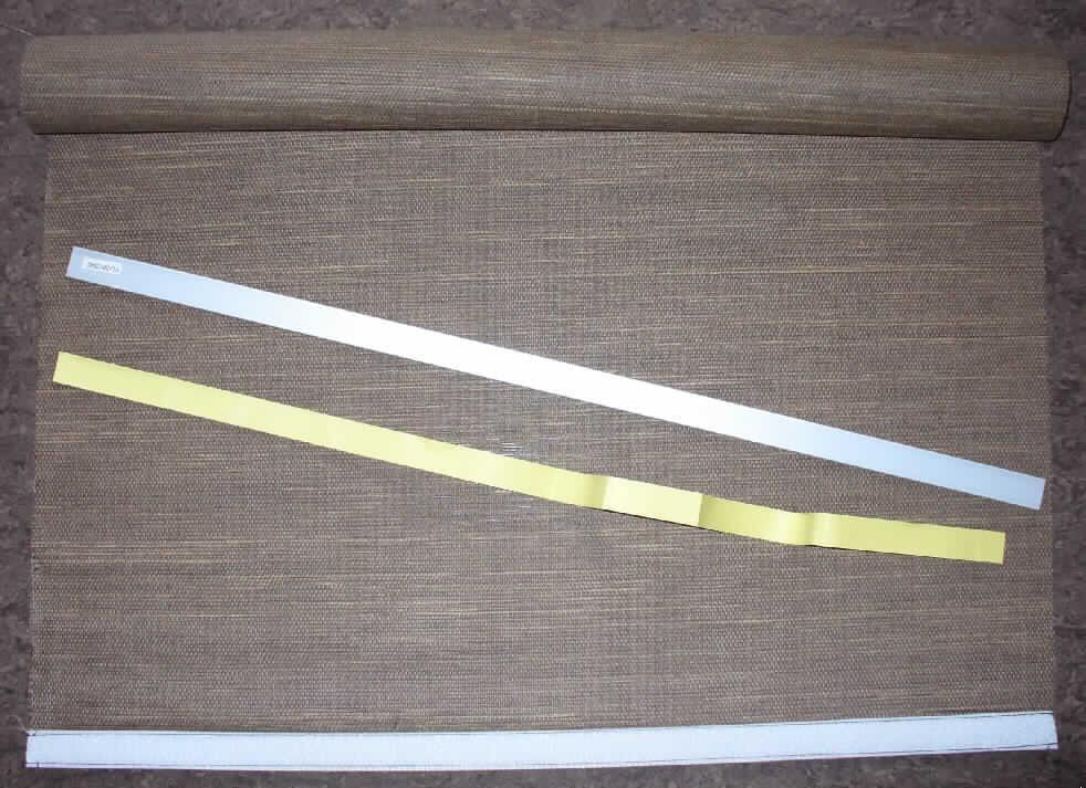 Flächenvorhang 
- rechteckig (Abmessungen ca. 60 x 245 cm),
- charakterverleihend aus ca. 2 mm breiten, gefalteten, biegsamen Streifen hergestellt (lt.
  Produktbeschreibung aus Bambus), die durch Haltefäden aus Spinnstoffgarnen in
  Flächenform parallel aneinander gefügt sind,
- an der oberen Schmalseite mit einem angenähten Klettband aus Spinnstoff zur Befestigung 
  an einem Paneelwagen ausgestattet,
- an der unteren Schmalseite mit einem ca. 4 cm breiten Saum versehen, zur Aufnahme
  eines beigefügten Beschwerstabes aus unedlem Metall (augenscheinlich aus Aluminium)
  bestimmt,
- ohne Hinweise auf eine Fertigung in Handarbeit,
- in einer klarsichtigen Kunststoffverpackung mit Montageanleitung aufgemacht.