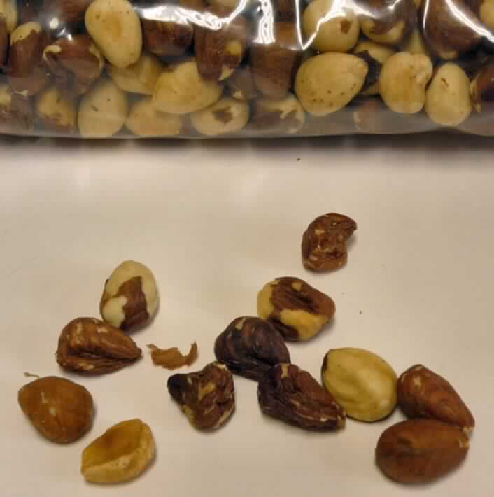 Haselnüsse, geröstet.

Antragsangaben (als zutreffend unterstellt): türkische Haselnüsse, leicht geröstet; Kaliber: 9/11; Verpackung: Big-Bags à 1.000 kg netto; Bearbeitung: Haselnusskerne werden in speziellen Röstmaschinen bei Temperaturen von ca. 115 bis 160 °C geröstet.

Beschaffenheit des zur verbindlichen Zolltarifauskunft DE 9825/11-1 vorgelegten Warenmusters:
ganze, beigefarbene bis leicht bräunliche, zum Teil sehr harte, artypisch, leicht bitter, aromatisch bis leicht geröstet schmeckende Haselnusskerne ohne Schale. Die Samenhaut ist bei einem Teil der Haselnusskerne gar nicht mehr oder nur noch zu einem Teil vorhanden. 

Die Haselnusskerne weisen nicht mehr den Charakter eines Erzeugnisses des Kapitels 8 auf.

Früchte, Nüsse und andere genießbare Pflanzenteile, in anderer Weise zubereitet oder haltbar gemacht, auch mit Zusatz von Zucker, anderen Süßmitteln oder Alkohol, anderweit weder genannt noch inbegriffen, Schalenfrüchte, andere, in unmittelbaren Umschließungen mit einem Gewicht des Inhalts von mehr als 1 kg, keine tropischen Nüsse, keine gerösteten Mandeln oder Pistazien, Haselnüsse.