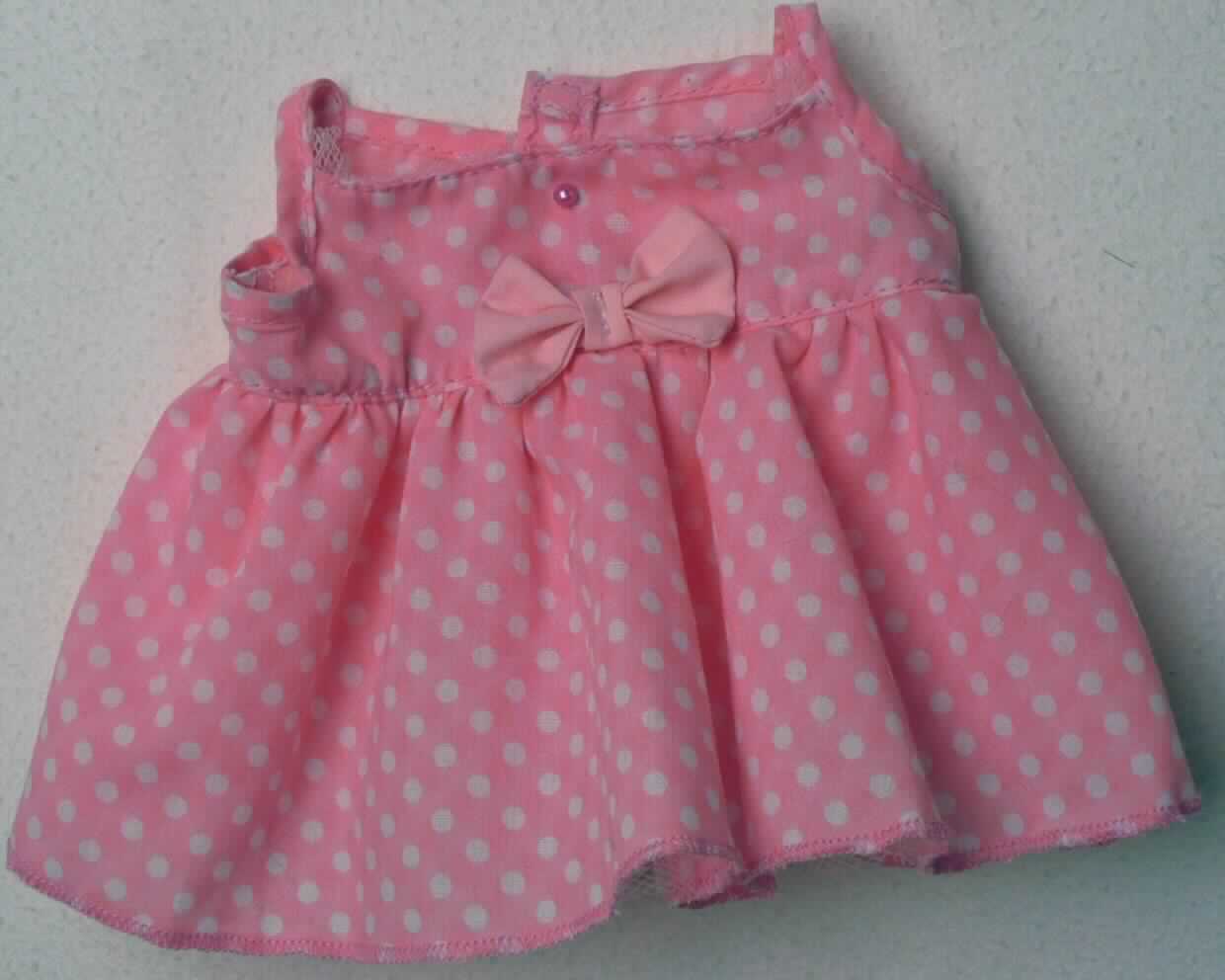 Es handelt sich um ein rosafarbenes, weiß gepunktetes, ca. 23 x 13 cam großes Kleid für eine Puppe. Das aus Spinnstoff bestehende Kleid ist im Rückenbereich mit einem Klettverschluss versehen und im Brustbereich mit einer Schleife verziert.

Die Ware ist aufgrund der Gestaltung erkennbar hauptsächlich als Zubehör für Puppen bestimmt und stellt sich als Puppenbekleidung dar. Eine mögliche Verwendung als Zubehör für Plüschtiere steht der Einreihung nicht entgegen. 

Das Erzeugnis dient der spielerischen Unterhaltung von Kindern mit Puppen und ist in einer Kunststofftüte verpackt.

Die Ware ist als "Zubehör für Puppen, nur Nachbildungen von Menschen darstellend" einzureihen.