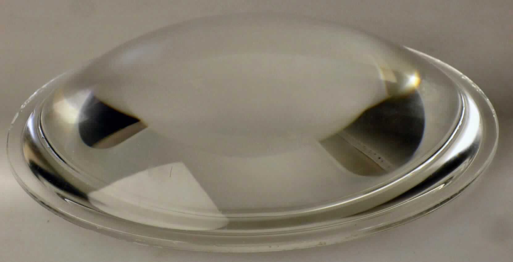 Bei der sog. "Linse (komplett aus Glas)" handelt es sich um einen runden, geschliffenen und polierten Glaskörper mit einem Durchmesser von ca. 10,8 cm und einer Höhe von 2,2 cm, welcher an einer Seite flach und an der anderen gewölbt gearbeitet ist.
Das Erzeugnis wird zur Lichtstreuung in einem elektrischen Beleuchtungskörper befestigt. 

Die Ware ist als "erkennbares Teil zum Ausstatten von elektrischen Beleuchtungskörpern, aus Glas" einzureihen.