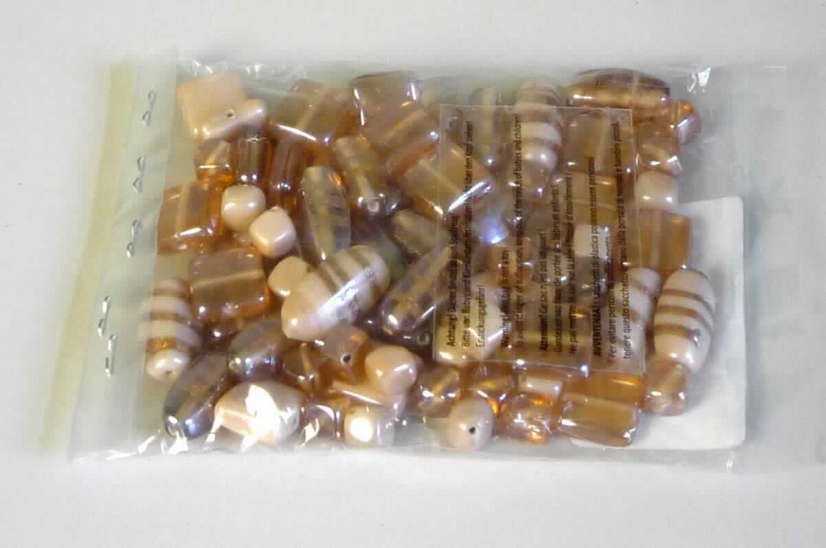 Glasperlen, sog. Glasperlenmix, apricot, Art.-Nr. 84200, Abbildung siehe Anlage, 
- verschiedenförmige, abgerundete, apricotfarbene, massive Perlen aus vollständig durchbohrtem Glas, 
- mit Größen zwischen 10 mm und 22 mm, 
- nicht geschliffen und mechanisch poliert, da die Perlen weder glatte oder scharfkantig abgegrenzte Schleifflächen 
  (Facetten) noch einen geschliffenen Lochrand aufweisen, 
- keine Nachahmung von echten Perlen, Zuchtperlen, Edel-, oder Schmucksteinen, 
- zum Herstellen von z.B. Halsketten u. ä. bestimmt, 
- keine Hinweise auf Handarbeit, 
- verpackt in einem Kunststoffbeutel.

"Glasperlen, nicht geschliffen und mechanisch poliert, nicht handgearbeitet"