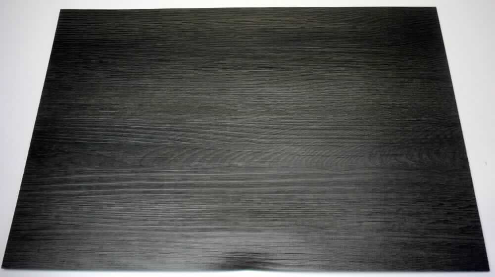 Angaben des Antragstellers:
Tischset mit geprägter Holzstruktur
Material: Vinyl

Untersuchungsergebnisse an einem Warenmuster:
Es wurde eine rechteckige, flexible, dreilagige Kunststoffplatte aus weichgemachtem Polyvinylchlorid (Abmessungen: ca. 45,5 x 30,5 x 0,2 cm) mit einer geprägten Oberseite in Holzoptik, einer dunkelgrauen Zwischenlage und einer schwarzen Unterseite mit Rautenprägung vorgelegt.

Befund:
Es liegt eine Platte aus weichgemachtem Polyvinylchlorid im Sinne der Position 3920 vor.