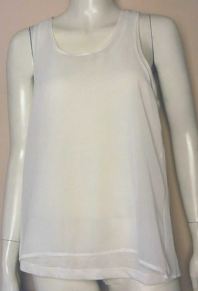 Bluse, sog. zusammenhängendes Top, Artikel 10151460, Größe M, Foto siehe Anlage,
- aus unterschiedlichen Flächenerzeugnissen aus Chemiefasern (laut Antrag aus Polyester, Viskose und Polyamid)
  zweilagig gearbeitet; an den Schulternähten zusammengenäht,
- Innenlage: 
-- aus ca. 0,6 mm dicken, einfarbigen Gewirken,
- Außenlage:
-- im Vorderteil aus einem ca. 0,4 mm dicken Gewebe,
-- im oberen Bereich des Rückenteils aus einem netzartigen, ca. 0,8 mm dicken Gewirke; unterhalb der Achseln
   aus dem gleichen Gewebe, aus dem das Vorderteil besteht,
- stellt sich aufgrund der Gesamtdicke (überwiegend ca. 1 mm) noch als leichtes Kleidungsstück dar,
- über die Taille reichend (Rückenlänge: ca. 65 cm),
- mit einem runden Halsausschnitt,
- ohne Öffnung; ohne Hinweise auf den Trägerkreis (unisex),
- ärmellos,
- an den unteren Rändern durch Umschlagen und Festnähen gesäumt,
- insbesondere im Hinblick auf das äußere Erscheinungsbild bestimmen die Gewebe den Charakter der Ware.

"Bluse, aus Geweben, für Frauen, aus Chemiefasern"