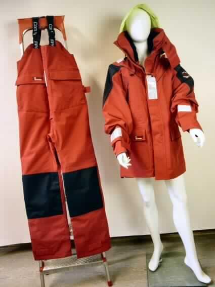 Zweiteilige Zusammenstellung bestehend aus einem Anorak und einer Latzhose, sog. Offshore Anzug 
Innovation Pro III, Art. 201340, Größe L, Foto siehe Anlage,
- in gemeinsamer Aufmachung für den Einzelverkauf,
- aus einem 0,5 mm dicken, dreilagigen Flächenerzeugnis mit einer charakterbestimmenden Außenlage 
  aus verschiedenfarbigen Geweben, einer Zwischenlage aus Kunststofffolie (kein Zellkunststoff),
  die im Querschnitt mit bloßem Auge nicht wahrnehmbar ist (somit nicht aus Meterware der Position 
  5903 und damit keine Kleidung der Position 6210) und einer Innenlage aus Gewirken, beide 
  Flächenerzeugnisse laut Antrag aus 100 % Nylon (synthetische Chemiefasern),
- durchgehend gefüttert
- nicht aus ein und demselben Flächenerzeugnis hergestellt (u. a. mit einer Kapuze aus
  andersfarbigen reflektierenden Geweben), deshalb keine Kombination,
- Latzhose:
-- mit einem Vorder- und Rückenlatz, mit angenähten, elastischen, längenverstellbaren Trägern 
   aus Geweben, mit Schnallenverschluss,
-- vorn mit einer Öffnung mit Reißverschluss und einer von links über rechts überlappenden Patte
   mit Klettverschluss (Männerkleidung),
-- mit zwei aufgesetzten Taschen, mit Klettverschlusspatte zu verschließen,
-- hinten mit einem elastischen, verengenden Einsatz und zusätzlich mit Riegeln zu verengen,
-- mit aufgenähten etwa 5 cm breiten, reflektierenden Streifen,
-- mit knöchellangen Hosenbeinen, an den Hosenbeinenden mit Klettverschlussriegel zu verengen.


"Latzhose aus Geweben (charakterbestimmend), für Männer, aus synthetischen Chemiefasern, keine 
 Arbeits- und Berufskleidung und Gewirken"
