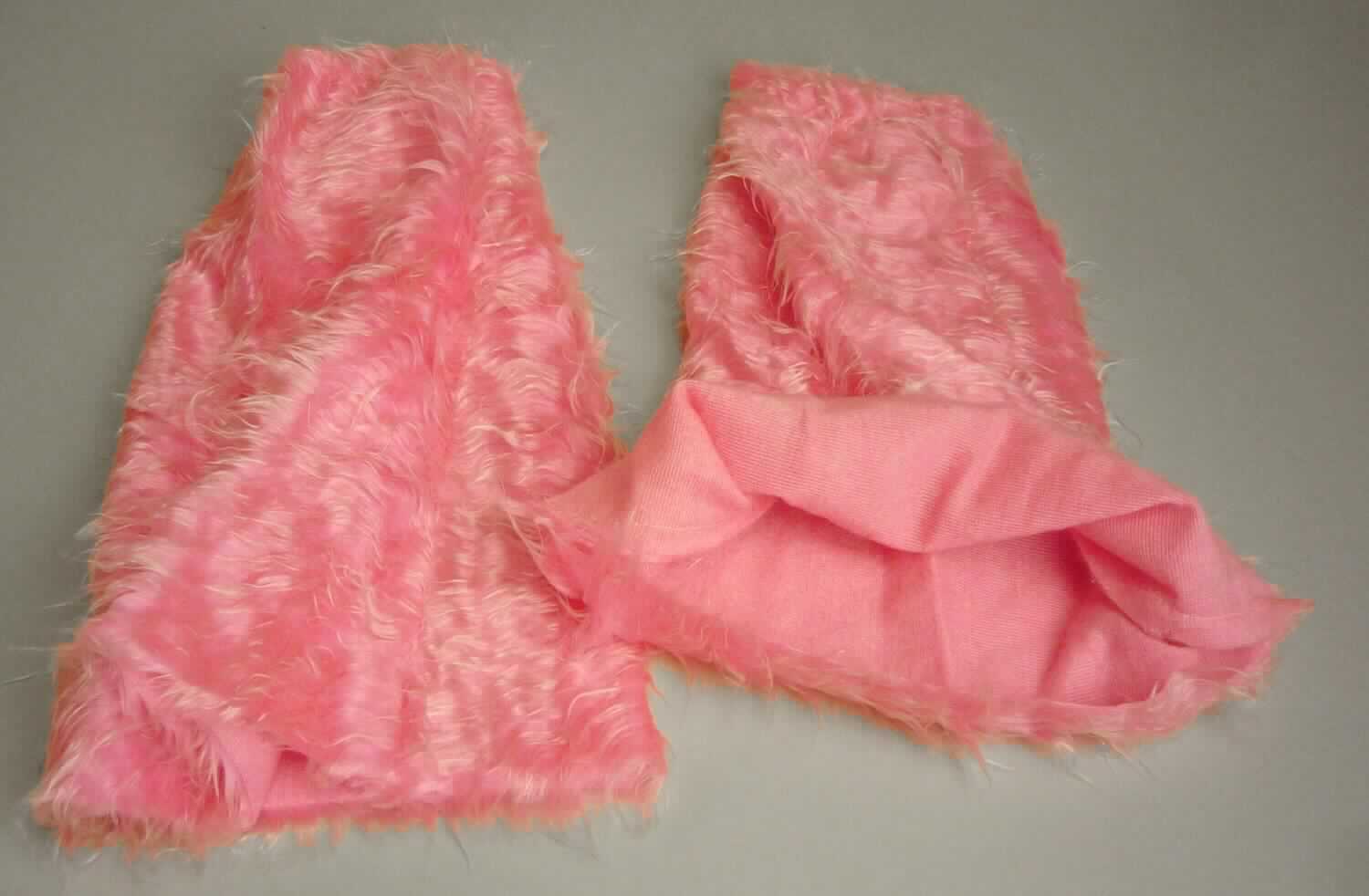 Gamaschenähnliche Waren (lt. Antrag: "Plüsch-Schlag pink, 45 cm, Art. 31918", Foto siehe Anlage)
- aus Spinnstoff (Plüschgewirke),
- den Unterschenkel bedeckend,
- mit einer Höhe von ca. 45 cm,
- oben ca. 13 cm breit, unten ca. 34 cm breit,
- am oberen Ende mit Gummizug

"Gamaschenähnliche Waren"