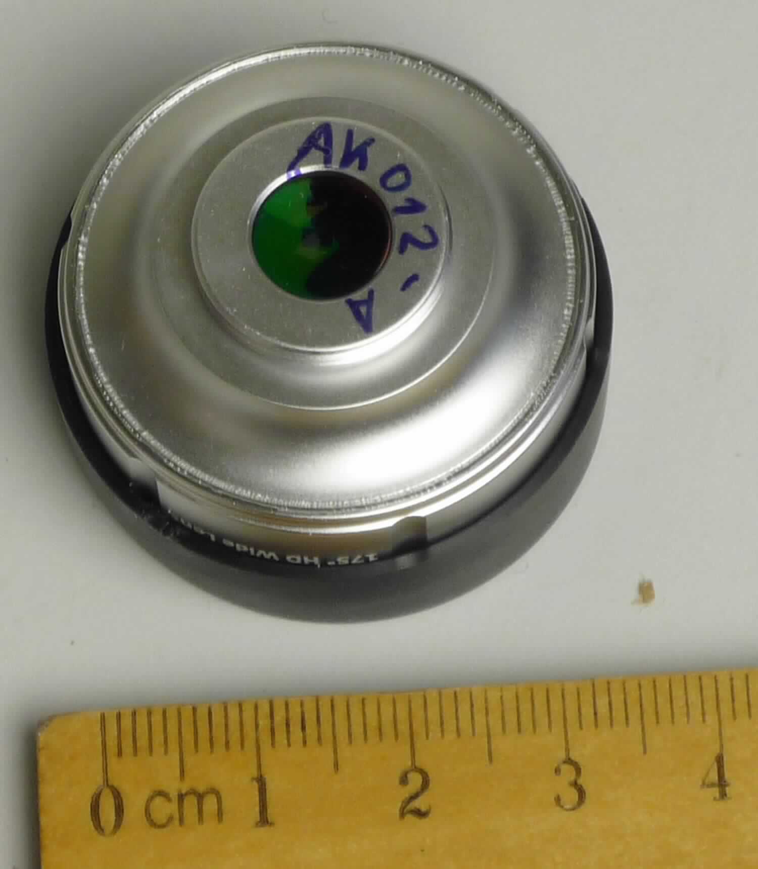 Sog. Objektiv Weitwinkel, Art. AK12-A, im Wesentlichen bestehend aus einem optisch bearbeitetem Glas (Ø der Linse: 27 mm) in einer Fassung aus unedlem Metall, als Weitwinkelobjektiv (Brennweite: 37 mm, Bildfeldwinkel: 175°, Zoomfaktor 0,35, Auflösung: 18 Linien/mm) für die integrierte Kamera eines Mobilfunktelefons (nicht Gegenstand dieser vZTA-Entscheidung) sowie einer Abdeckkappe zum Schutz des Objektivs vor Verschmutzung und Beschädigung.

äußere Form: siehe Abbildung in Anlage

Mittels einer speziellen Halterung aus Kunststoff (nicht Gegenstand dieser vZTA-Entscheidung) wird das Objektiv vor die Kameralinse eines Mobilfunktelefons befestigt und ermöglicht vielfältigere Aufnahmeoptionen, wie z. B. Panoramabilder etc.

Die Ware wird als "optisches Element, nicht aus optisch nicht bearbeitetem Glas, für Instrumente, Apparate und Geräte, gefasst, Objektiv, für Kameras, nicht von den Unterpositionen (TARIC) 9002 1100 10 bis 9002 1100 80 erfasst" eingereiht.