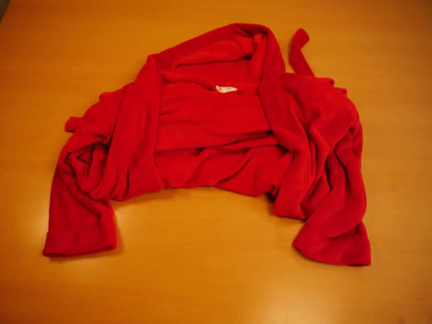 Bademantel, sog. Bademantel Malibu, Größe L, Foto siehe Anlage,
- in einem Polybeutel verpackt,
- aus ca. 2,6 mm dicken, einfarbigen Plüschgewirken aus lt. Antrag 100% Polyester (synthetische Chemiefasern),
- über das Knie reichend (Rückenlänge: ca. 138 cm),
- mit einer Kapuze,
- vorn mit einer durchgehenden Öffnung ohne Verschluss; ohne Hinweise auf den Trägerkreis (unisex),
- mit einem durch Schlaufen gezogenen Bindegürtel aus Plüschgewirken,
- vorn mit zwei aufgesetzten, offenen Taschen, 
- am unteren Rand durch Umschlagen und Festnähen gesäumt.

"Bademantel, aus Gewirken, für Frauen, aus Chemiefasern"