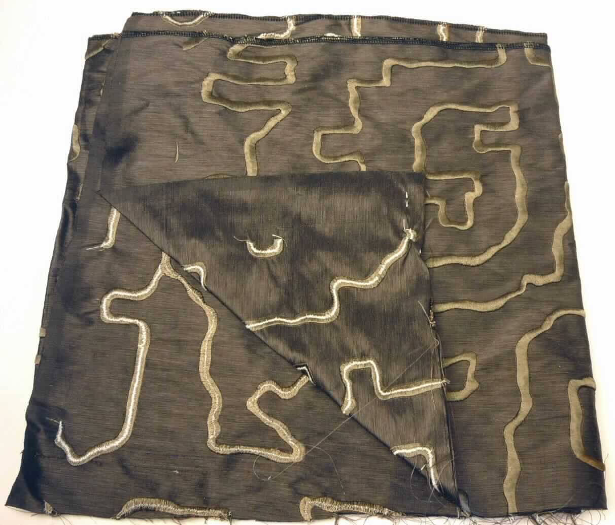 Stickerei, sog. Stoff, Art.Nr. 2617-01 bis 06 Verdi, Foto siehe Anlage,
- als Meterware; mit einer Breite laut Antrag von 139 cm,
- laut Untersuchungsergebnis:
-- maschinelle Stickerei mit Ober- und Unterfaden,
-- keine Ätzstickerei oder Stickerei mit herausgeschnittenem Grund,
-- mit einem Stickgrund aus Geweben aus 100 % Seide sowie diesen Grund verzierenden Stickfäden aus
   laut Antrag künstliche Chemiefasern,
- laut Antrag mit einem Wert von mehr als 17,50 EURO je kg Eigengewicht.

"Stickerei als Meterware, andere als in Unterposition 5810 10 genannte, aus Seide, mit einem Wert von 
 mehr als 17,50 EUR je kg Eigengewicht, nicht handgearbeitet"