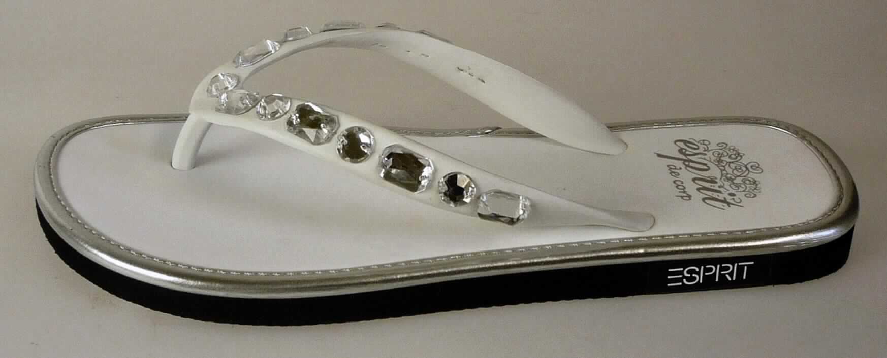 Zehenstegsandalen (lt. Antrag: "Flip Flops für Damen / Mädchen"; Foto siehe Anlage)
- mit Laufsohlen aus (lt. Antrag) Kunststoff,
- mit zehenfreiem Oberteil aus Kunststoffriemen (an drei Punkten mit der Sohle durch Zapfen zusammengesteckt),
- mit Zierbesatz (Strasssteine)

"Schuhe mit Laufsohlen aus Kunststoff und Oberteil aus Riemen aus Kunststoff, mit der Sohle durch Zapfen 
 zusammengesteckt, keine Sportschuhe"