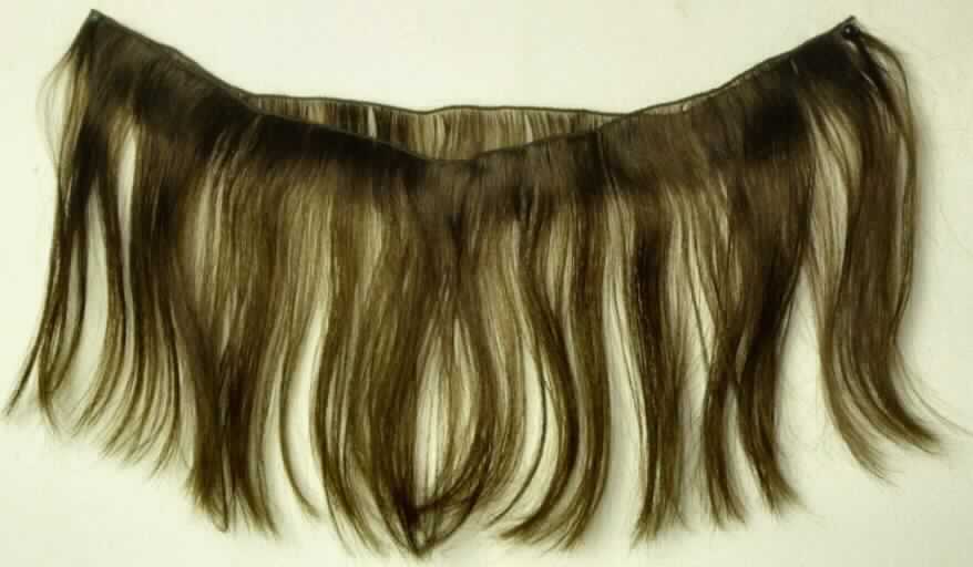 Haarsträhnen (Tresse) aus Menschenhaaren, sog. Maschinentresse, Abbildung siehe Anlage, 
- gebrauchsfertige Perückenmacherware in Form von Haarsträhnen (Tressen) mit Breiten ab 10 cm, 
- aus Menschenhaaren (lt. Antrag), 
- gleichgerichtete Menschenhaare, büschelweise auf eine Schnur genäht (weiterbearbeitet als nur gleichgerichtet 
  sowie in anderer Weise zugerichtet), 
- mit einer Haarlänge von 10 cm bis 75 cm, 
- lt. Antrag zur Herstellung von Haarteilen oder zum Einarbeiten ins Eigenhaar.

"Haarsträhnen, aus Menschenhaaren"