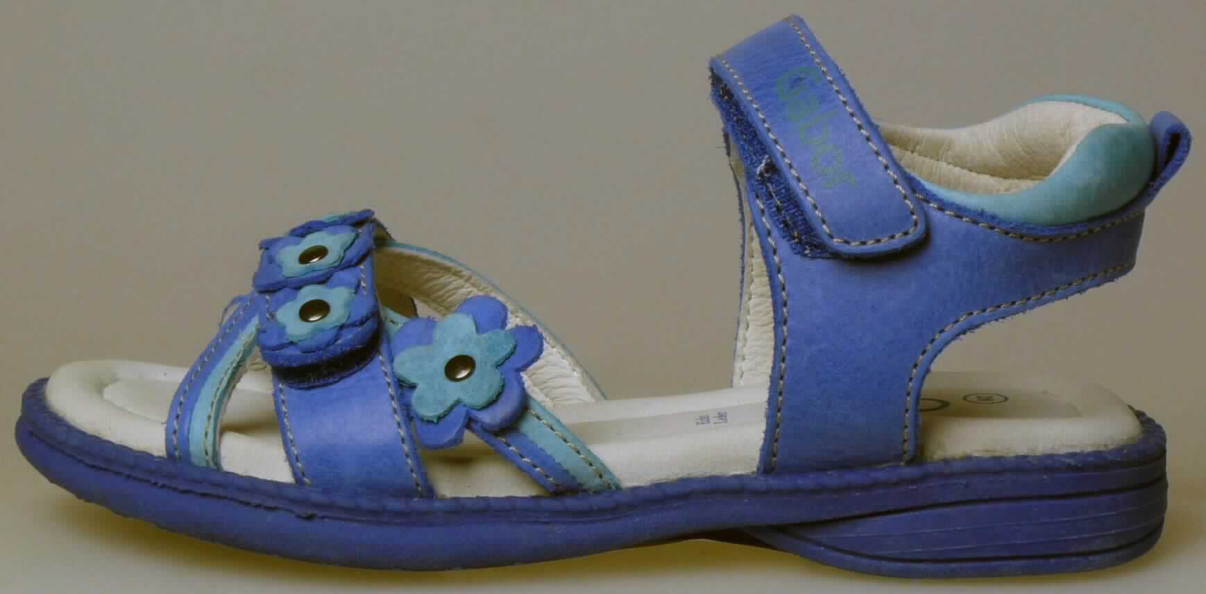 Freizeitsandalen (lt. Antrag: "Artikel-Nr. 87 272 03, Kinderschuh", Foto siehe Anlage)
- mit Laufsohlen aus (lt. Antrag) Kautschuk; ohne Hauptsohle aus Holz, 
- mit zehenfreiem Oberteil (nicht geschlossenes Blatt) aus Leder,
- mit Zierbesatz (stilisierte Blüten aus Leder),
- mit Klettverschluss,
- ohne Metallschutz in der Vorderkappe,
- nicht den Knöchel bedeckend, 
- mit einer größten Höhe des Absatzes und der Sohle von weniger als 3 cm,
- mit einer Länge der Innensohle von weniger als 24 cm

"Schuhe mit Laufsohlen aus Kautschuk und Oberteil aus Leder, andere als in den UPos. 6403 1200 bis 
 6403 9911 genannt, mit einer Länge der Innensohle von weniger als 24 cm"