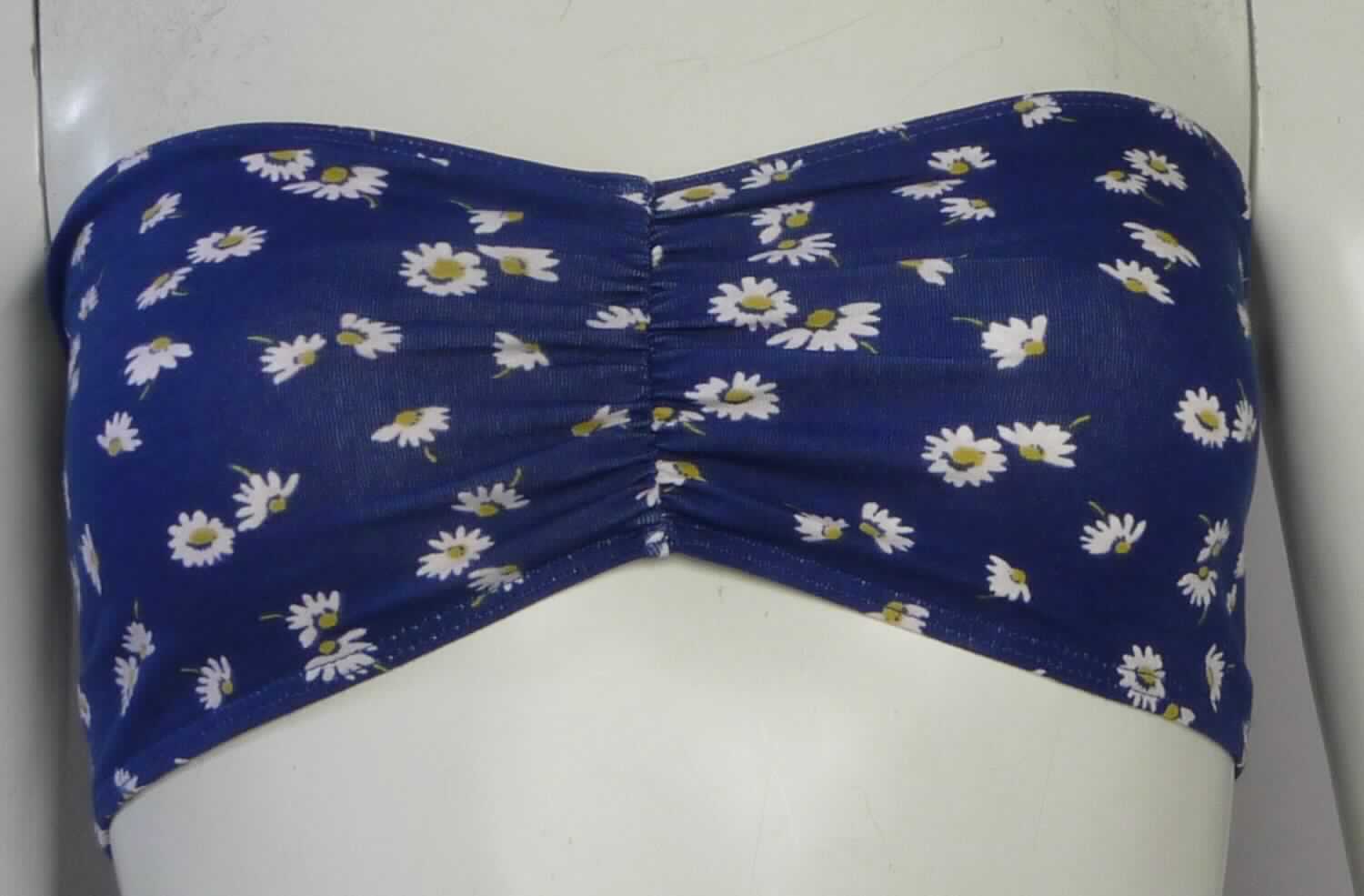 Andere Kleidung, sog. Schlauchtop für Frauen, Art. RSA8341P, Größe M, Foto siehe Anlage,
- aus ca. 0,8 mm dicken, floral bedruckten Gewirken aus laut Antrag 95 % Baumwolle und 5 % Elasthan
  (synthetische Chemiefasern),
- in der Art eines Bustiers gearbeitet; mit einer Breite von ca. 32 cm und einer Höhe von bis zu 12,5 cm,
- trägerlos und schulterfrei,
- lediglich die Brust bedeckend, stellt sich somit nicht als ein den Oberkörper bedeckendes Kleidungsstück dar,
- in der Mitte des Brustbereichs durch ein innen eingenähtes, elastisches Band gerafft,
- am oberen und unteren Rand durch Umschlagen und Festnähen gesäumt sowie mit eingenähten, elastischen 
  Bändern ausgestattet,
- formt, korrigiert und stützt nicht die Einzelbrust, somit kein Büstenhalter der Position 6212.

"Kleidung, andere als in den Positionen 6101 bis 6113 genannte, aus Gewirken, aus Baumwolle"