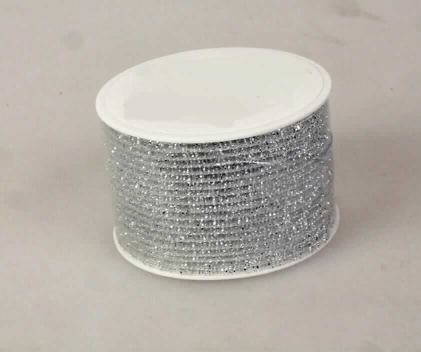 Kettengewirke, sog. Band silber, Art. 290-012, Foto siehe Anlage,
- auf einer Rolle aus Kunststoff aufgewickelt,
- als Meterware; mit einer Breite von ca. 4 cm und einer Länge von lt. Antrag 2 m,
- ohne Flor- oder Schlingenoberfäche,
- laut Untersuchungsergebnis:
-- Kettengewirke, 
--- mit maschenbildenden Garnen und Stehfäden aus synthetischen Monofilen,
--- mit Schussgarnen der Position 5605, bestehend aus einem metallisierten Streifen aus synthetischer Spinn- 
    masse mit einer Breite von ca. 1 mm, der mit zwei Monofilamenten kreuzweise umwickelt ist,
--- mit einem überwiegenden Anteil an synthetischen Chemiefasern,
-- keine Elastomergarne oder Kautschukfäden enthaltend,
-- Raschelspitze.

"Gewirke, mit einer Breite von weniger als 30 cm, anderes als in den Positionen 6001 und 6002 genannte, 
 aus synthetischen Chemiefasern, Raschelspitze"