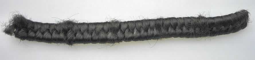 Spinnstoffe, für die Herstellung von Perücken zugerichtet, sog. Haarkrepp, Abbildung siehe Anlage,
- Krepp, bestehend aus einer Unterlage aus zwei parallel gelegten Schnüren, 
- mit einem Florband aus (laut Antrag) Spinnstoffen (Chemiefasern) umschlungen, 
- mit dem Aussehen eines Geflechts, 
- Meterware mit einer Länge von 2 Meter und einem Gewicht von ca. 100 Gramm, 
- gilt als zur Herstellung von Perücken und ähnlichen Waren aufbereitet.

"Spinnstoffe, für die Herstellung von Perücken und ähnlichen Waren zugerichtet"
