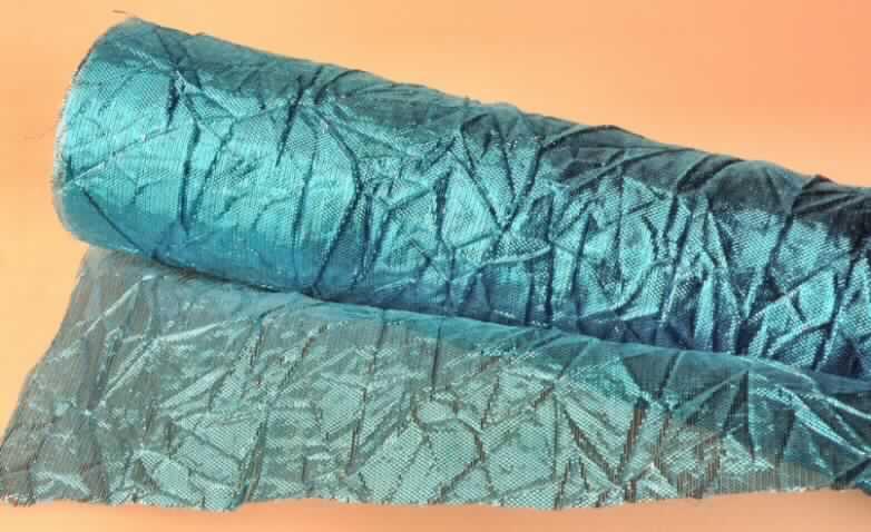 Gewebe, sog. Dekorationsstoff auf Rolle Art.5, Foto siehe Anlage,
- als Meterware
- mit einer Breite von 40 cm,
- laut Untersuchungsergebnis:
-- aus 60 GHT metalisierten Streifen (Breite ca. 1 mm) aus synthetischer Spinnmasse 
  (= metallisierte Garne; Kette) und 40 GHT synthetischen Filamenten aus Polyamid (Schuss)
-- gecrasht; in Leinwandbindung,
- laut Antrag an den Längskanten lediglich heiß geschnitten, somit nicht konfektioniert,
- von der zur Innenausstattung verwendeten Art.

"Gewebe aus metallisierten Garnen der Position 5605, von der zur Innenausstattung
 verwendeten Art, anderweit weder genannt noch inbegriffen"