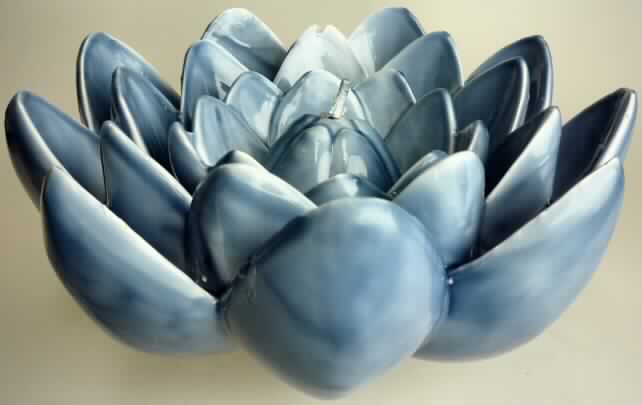 Sog. "Lotus-Schwimmkerze" (s. Foto)
Es handelt sich um eine zusammengesetzte Ware, bestehend aus:
- einer ca. 9,5 cm hohen, im Durchmesser 21,5 cm großen Schale aus blauem, geschnitztem Wachs in Form einer Lotusblume und
- einer ca. 6 cm hohen, im Durchmesser 10,5 cm großen Kerze aus blauem, geschnitzten Wachs in Form einer Lotusblüte.
Stellt man die Kerze in die Schale, so ergibt dies eine vollständige Lotusblume.
Die Schale bestimmt den Charakter der zusammengesetzten Ware im Hinblick auf den Umfang und die Bedeutung für die Verwendung.
Hinweise auf eine Handarbeit liegen nicht vor.

Die Ware ist als "geschnitzte Ware aus Wachs, anderweit weder genannt noch inbegriffen, nicht handgearbeitet" einzureihen.