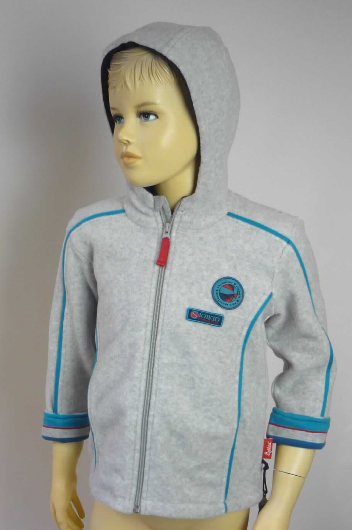 Jacke, sog. Kinder Fleece-Jacke, Art. 157515, Größe 116, Foto siehe Anlage,
- gemeinsam mit einem an einer Schlaufe befestigten Deko-Anhänger in einem Polybeutel verpackt; 
  der Deko-Anhänger ist geringwertig und im Hinblick auf die Verwendung als unbedeutend zu betrachten, 
  er ändert das Wesen der Hauptware nicht und ist deshalb wie diese einzureihen,
- aus ca. 2,2 mm dicken, einfarbigen, beidseitig gerauten Gewirken (sog. Fleece) aus laut Antrag 100 % Polyester
  (synthetische Chemiefasern),
- durchgehend leicht gefüttert,
- über den Schritt reichend (Rückenlänge: ca. 48 cm), 
- in Bahnen gearbeitet,
- mit einem Stehkragen und einer Kapuze,
- vorn mit einer durchgehenden Öffnung mit einem bis an den Kragenrand reichenden Reißverschluss, am
  Kragenrand mit einer kurzen Überlappung von rechts über links (Mädchenkleidung),
- mit langen Ärmeln, an den Abschlüssen gesäumt,
- mit zwei offenen Taschen unterhalb der Taille,
- mit diversen kontrastfarbenen Paspeln und im linken Brustbereich mit aufgestickten Firmenlogos verziert,
- am unteren Rand durch Umschlagen und Festnähen gesäumt,
- wird im Allgemeinen nicht über jeder anderen Kleidung und zum Schutz gegen das Wetter getragen, 
  somit keine Kleidung der Position 6102.

"Jacke, aus Gewirken, für Mädchen, aus synthetischen Chemiefasern"