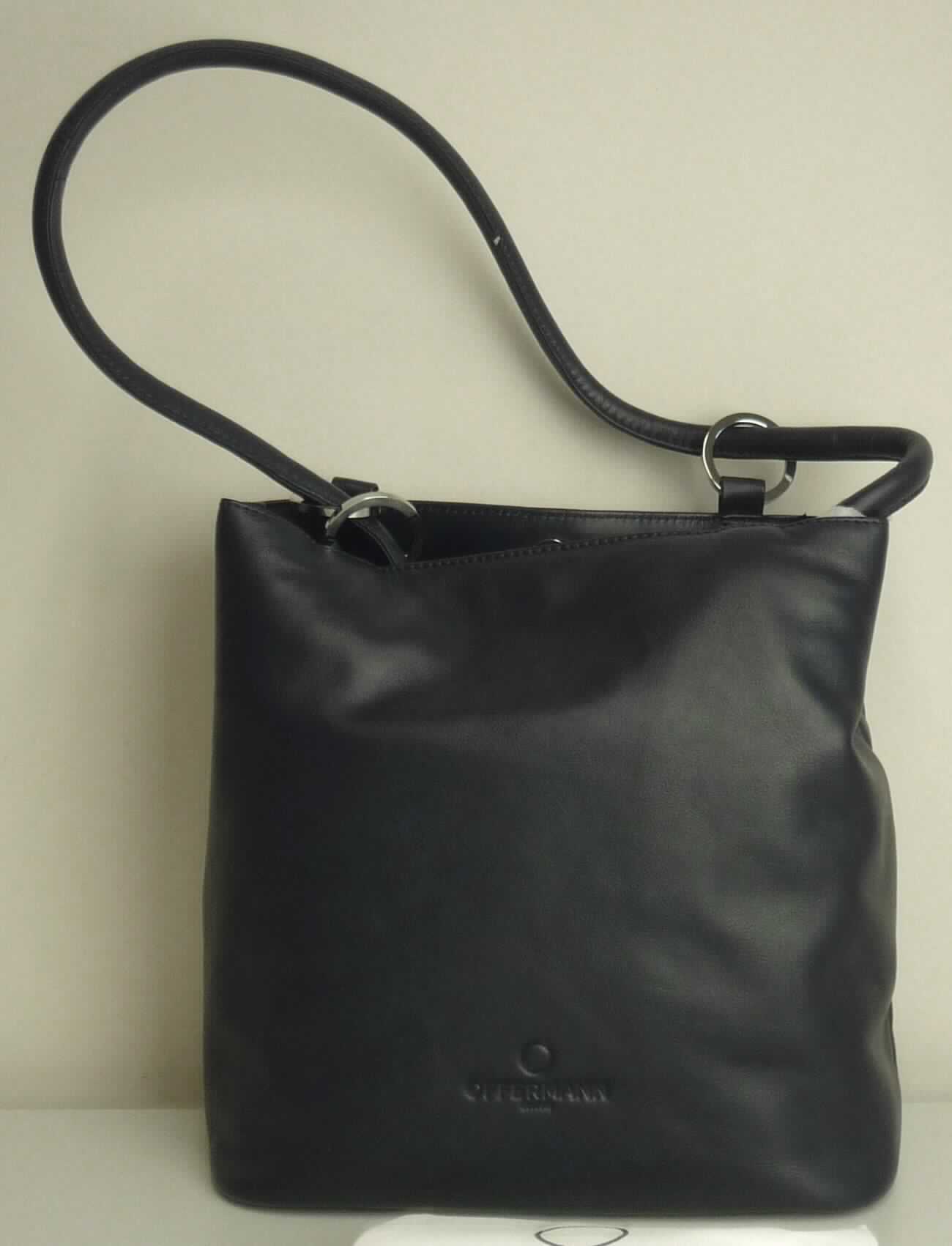 Ähnliches Behältnis, sog. Bucket Bag Medium - Damen-Handtasche, Abbildung siehe Anlage, 
- gemeinsam mit einem einfachen Beutel aus Spinnstoffen für den Einzelverkauf aufgemacht (der Beutel ist in die  
  Tasche eingelegt); der Beutel ist geringwertig und im Hinblick auf die Verwendung als unbedeutend zu betrachten, 
  er ändert das Wesen der Hauptware nicht und ist deshalb wie diese einzureihen,
- mit einer Außenseite aus Leder, 
- mit einem Handtrage-/bzw. Schultertrageriemen, 
- an einer Schmalseite mit einem vertikal eingesetzten Reißverschlussfach, 
- am oberen Ende mit einem Magentknopfverschluss, 
- innen mit einem Mittelstegfach mit Reißverschluss, einem weiteren eingesetzten Reißverschlussfach, zwei 
  Einsteckfächern, zwei Stiftschlaufen und einem abnehmbaren Schlüsselband mit Karabinerhaken, gefüttert, 
- am Boden mir vier Metallfüßchen, 
- mit den Abmessungen von ca. 27 cm (Breite) x 27 cm (Höhe) x 15 cm (Tiefe), 
- keine Hinweise auf Handarbeit, 
- keine Einreihung als Handtasche aufgrund der Ausstattung (kein ausreichender Verschluss) und der Größe, 
- eingesteckt in eine Kunststofftüte, verpackt in einen Karton.

"Ähnliches Behältnis, anderes als in den Unterpositionen 4202 1110 bis 4202 3900 genannte, mit Außenseite 
 aus Leder, anderes als in der Unterposition 4202 9110 genannte, nicht handgearbeitet"