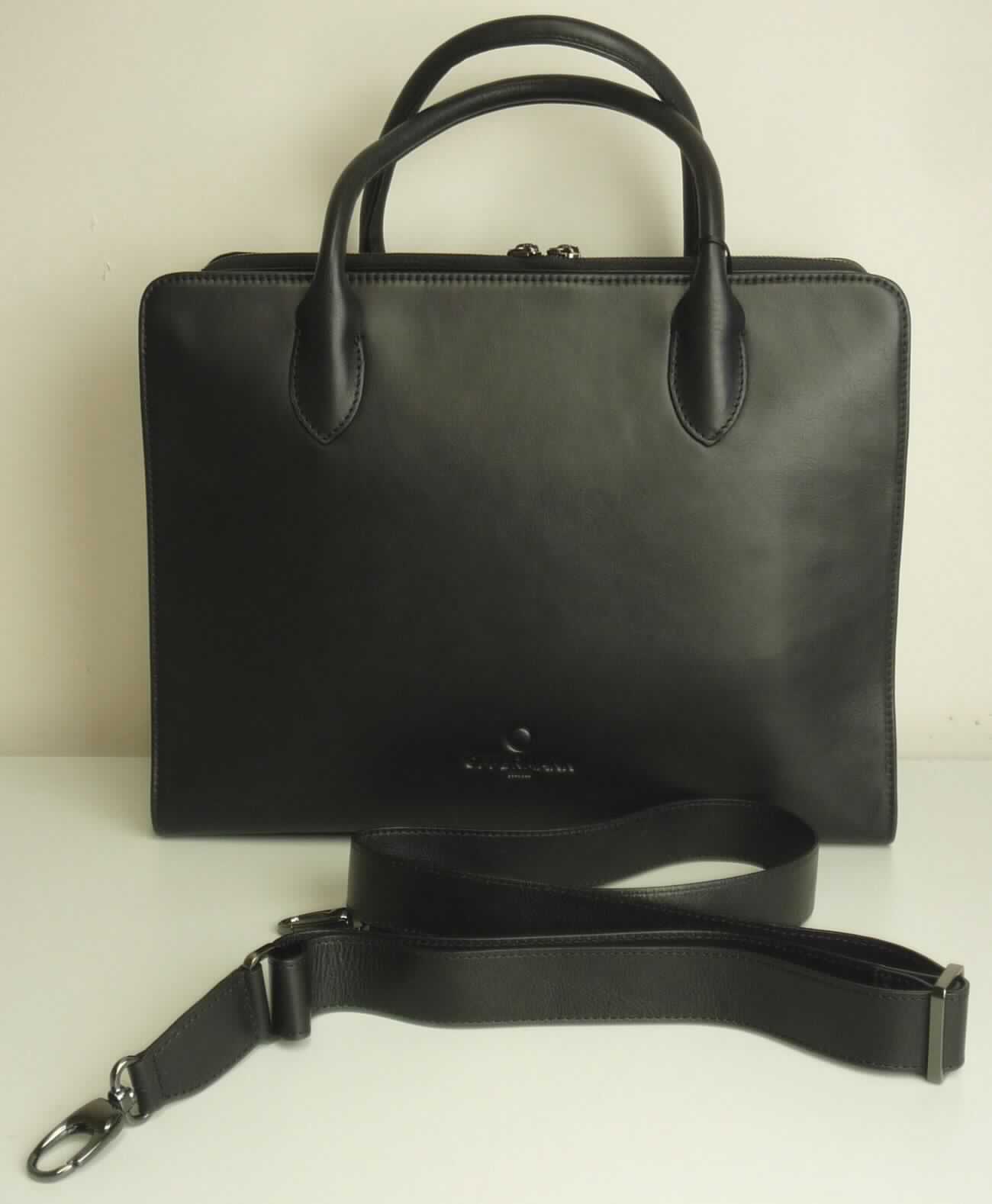 Ähnliches Behältnis, sog. Work Shape - Damen-Businesstasche, Abbildung siehe Anlage, 
- gemeinsam mit einem einfachen Beutel aus Spinnstoffen für den Einzelverkauf aufgemacht (der Beutel ist in die  
  Tasche eingelegt); der Beutel ist geringwertig und im Hinblick auf die Verwendung als unbedeutend zu betrachten, 
  er ändert das Wesen der Hauptware nicht und ist deshalb wie diese einzureihen,
- mit einer Außenseite aus Leder, 
- mit zwei Handtrageriemen und einem abnehmbaren, verstellbaren Schultertragegurt, 
- am oberen Ende ohne Verschluss, 
- innen mit drei Fächern, 
- - mit einem Mittelstegfach mit einem über drei Seiten umlaufenden Reißverschluss, 
- - mit zwei Außenfächern, eines mit einem eingesetzten Reißverschlussfach und einem abnehmbaren Schlüssel- 
    band mit Karabinerhaken, das andere mit drei aufgesetzten Einsteckfächern und zwei Stiftschlaufen, 
- - gefüttert, 
- am Boden mir vier Metallfüßchen, 
- mit den Abmessungen von ca. 36 cm (Breite) x 28 cm (Höhe) x 16 cm (Tiefe), 
- keine Hinweise auf Handarbeit, 
- keine Einreihung als Handtasche aufgrund der Ausstattung (kein ausreichender Verschluss) und der Größe, 
- eingesteckt in eine Kunststofftüte, verpackt in einen Karton.

"Ähnliches Behältnis, anderes als in den Unterpositionen 4202 1110 bis 4202 3900 genannte, mit Außenseite 
 aus Leder, anderes als in der Unterposition 4202 9110 genannte, nicht handgearbeitet"