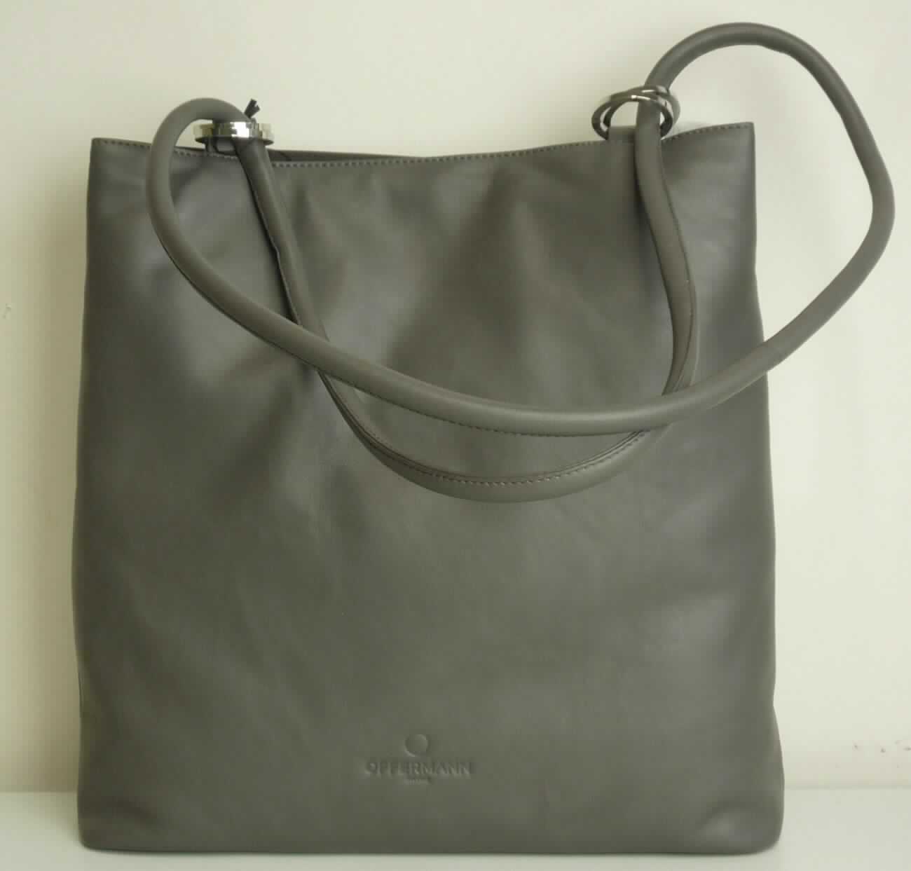 Ähnliches Behältnis, sog. Bucket Bag Large - Damen-Handtasche, Abbildung siehe Anlage, 
- gemeinsam mit einem einfachen Beutel aus Spinnstoffen für den Einzelverkauf aufgemacht (der Beutel ist in die  
  Tasche eingelegt); der Beutel ist geringwertig und im Hinblick auf die Verwendung als unbedeutend zu betrachten, 
  er ändert das Wesen der Hauptware nicht und ist deshalb wie diese einzureihen,
- mit einer Außenseite aus Leder, 
- mit einem Handtrage-/bzw. Schultertrageriemen, 
- an einer Schmalseite mit einem vertikal eingesetzten Reißverschlussfach, 
- am oberen Ende mit einem Magentknopfverschluss, 
- innen mit einem Mittelstegfach mit Reißverschluss, einem weiteren eingesetzten Reißverschlussfach, zwei 
  Einsteckfächern, zwei Stiftschlaufen und einem abnehmbaren Schlüsselband mit Karabinerhaken, gefüttert, 
- am Boden mir vier Metallfüßchen, 
- mit den Abmessungen von ca. 36 cm (Breite) x 36 cm (Höhe) x 12 cm (Tiefe), 
- keine Hinweise auf Handarbeit, 
- keine Einreihung als Handtasche aufgrund der Ausstattung (kein ausreichender Verschluss) und der Größe, 
- eingesteckt in eine Kunststofftüte, verpackt in einen Karton.

"Ähnliches Behältnis, anderes als in den Unterpositionen 4202 1110 bis 4202 3900 genannte, mit Außenseite 
 aus Leder, anderes als in der Unterposition 4202 9110 genannte, nicht handgearbeitet"