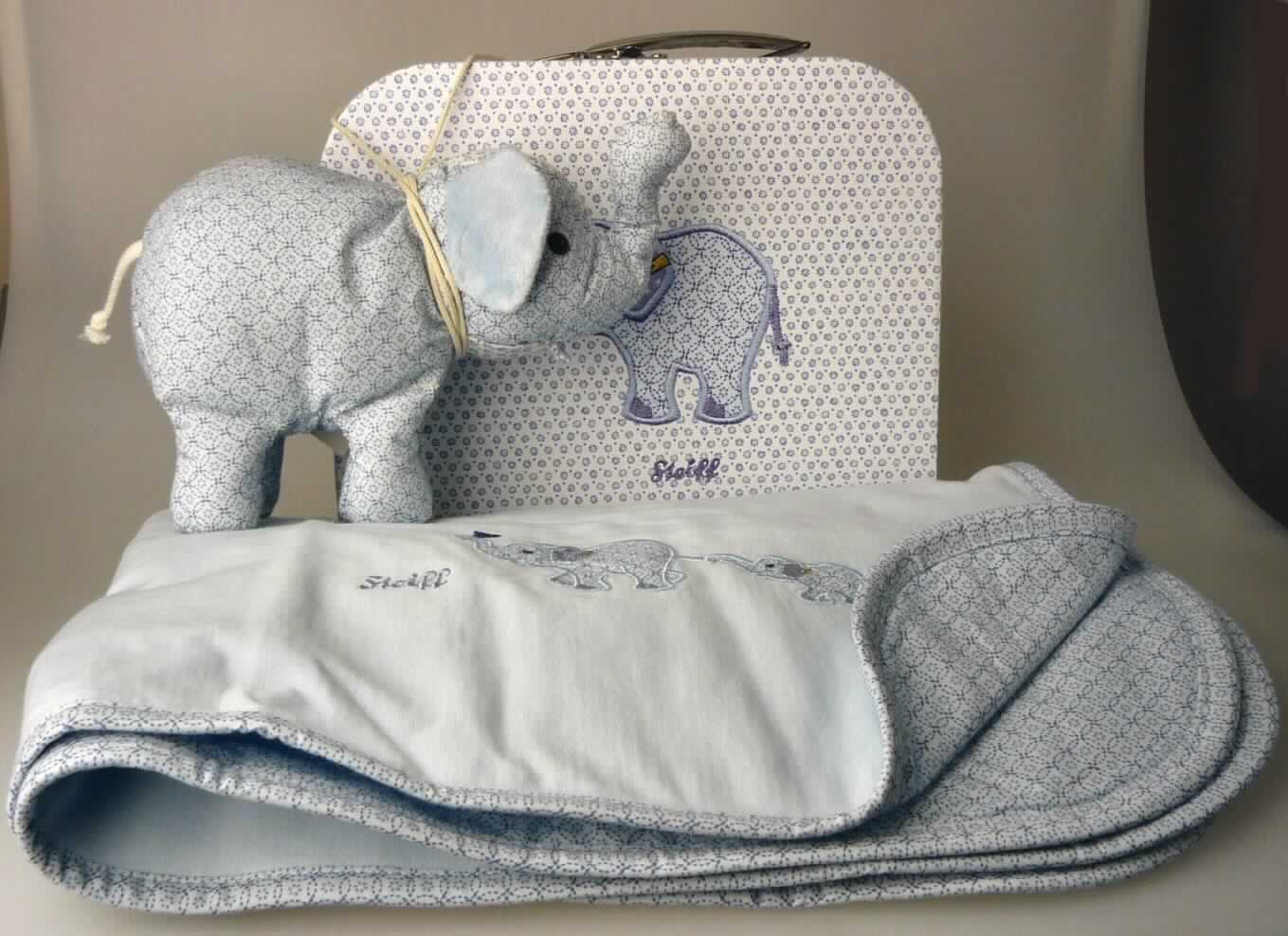 Dreiteilige Zusammenstellung bestehend aus einem Spielzeug, einem handkofferähnlichen Behältnis und einer Decke, sog. Steiffs kleiner Zirkus-Elefant Geschenkset groß, EAN 235863, Foto siehe Anlage, 
- die Waren dienen weder der Befriedigung eines speziellen Bedarfs noch der Ausübung einer bestimmten Tätigkeit
  und stellen somit keine Warenzusammenstellung i.S. der AV 3 b) dar, sondern sind getrennt einzureihen,
- handkofferähnliches Behältnis:
-- mit einer Außenseite aus buntbedrucktem Papier, 
-- mit einem Handtragegriff aus unedlem Metall ausgestattet, 
-- mit den Abmessungen von ca. 24 (B) x 18 (H) x 10 (T) cm, 
-- mit einem Bügelverschluss aus unedlem Metall zu öffnen, 
-- innen ohne Einteilung oder Ausstattung, 
-- keine Hinweise auf Handarbeit.

"Handkofferähnliches Behältnis, mit einer Außenseite aus Papier, nicht handgearbeitet"