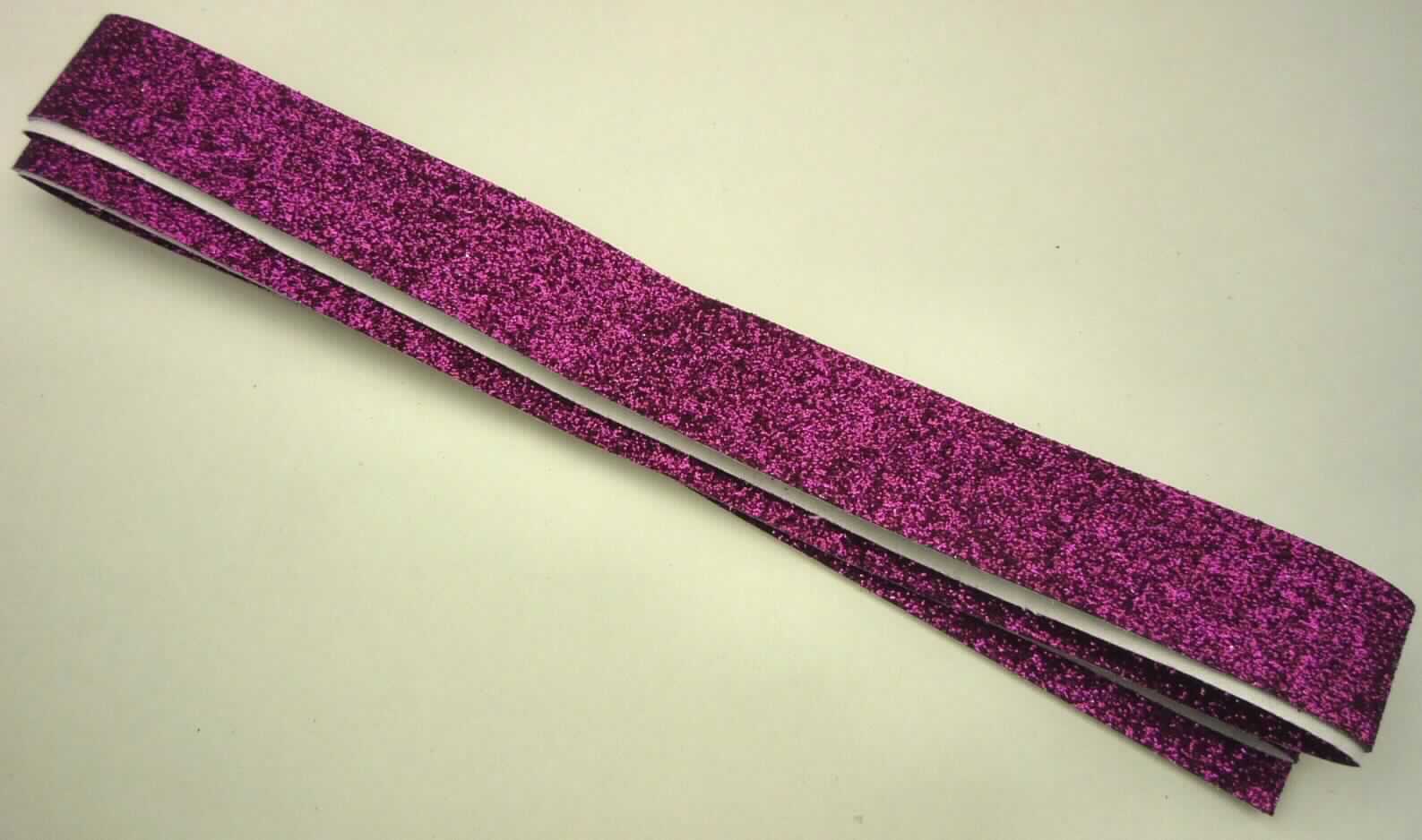 Gewebe, sog. Dekoklebeband, Foto siehe Anlage,
- als Meterware; laut Antrag mit einer Breite von 1,5 cm und einer Länge von 5 m,
- laut Untersuchungsergebnis:
-- schwarzes Gewebe in Leinwandbindung aus Chemiefasern,
--- auf der Schauseite auf der ganzen Oberfläche mit klarsichtigem Kleber bestrichen
    und mit metallisierten Partikeln (keine Kügelchen) überdeckt,
--- auf der Rückseite mit Kleber und Abdeckpapier versehen.

"Überzogenes Gewebe, anderes als in den Positionen 5901 bis 5906 genannte,
 ohne in Klebstoff eingebettete Kügelchen"