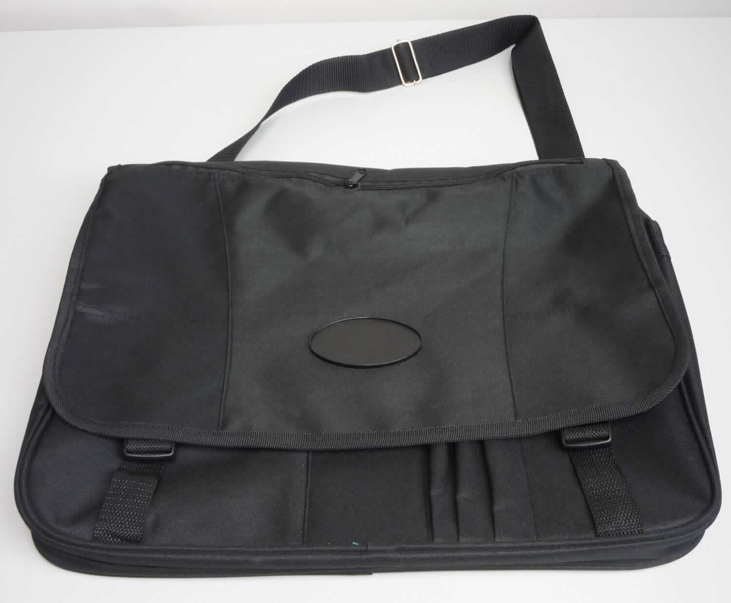 Aktentaschenähnliches Behältnis, Business Bag - Tragetasche, Foto siehe Anlage,
- mit einer Außenseite aus Spinnstoffen,
- - auf der Außenseite der Überschlagklappe mit einem ovalen Aufsatz aus Kunststoff,
- mit einem abnehmbaren, längenverstellbaren Schultertragegurt und einem Handtragegriff,
- mit einer Überschlagklappe,
- - mit zwei Schnappverschlüssen,
- - mit einem eingesetzten Reißverschlussfach,
- mit zwei großen und zwei kleineren aufgesetzten, offenen Vorfächern, vier Stiftlaschen und einem Reißver-
  schlussfach; verdeckt von der Überschlagklappe,
- mit einem Hauptfach,
- - mit einem entlang des oberen Rands verlaufenden, von der Überschlagklappe verdeckten Reißverschluss,
- - ohne Einteilung; ungefüttert,
- - entlang der Schmalseiten und des unteren Rands mit einer Dehnfalte mit Reißverschluss,
- in den Abmessungen: ca. 40 cm (Breite) x 31 cm (Höhe) x 8 cm (Tiefe),
- ohne Hinweise auf Handarbeit.

"Aktentaschenähnliches Behältnis, mit Außenseite aus Spinnstoffen, nicht handgearbeitet"
