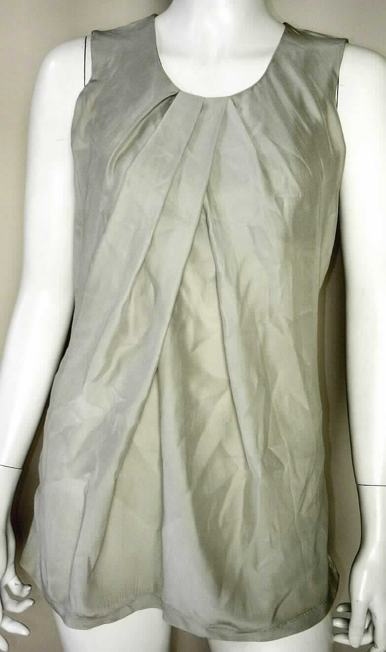 Bluse, sog. ärmelloses Shirt, Artikel Nr. 326045/13021/920, Größe 36, Foto siehe Anlage,
-  bestehend aus:
-- einem Vorderteil aus ca. 0,3 mm dicken, leichten, einfarbigen Geweben aus laut Antrag 100% Seide,
   das im Brustbereich mit einem Zuschnitt aus ca. 0,6 mm dicken Gewirken aus laut Antrag 100 % Baumwolle 
   unterlegt ist, insgesamt liegt jedoch noch ein leichtes Kleidungsstück vor,
-- einem Rückenteil aus ca. 0,6 mm dicken, leichten, einfarbigen Gewirken aus laut Antrag 100 % Baumwolle,   
- über die Taille reichend (Rückenlänge: etwa 68 cm), 
- mit einem runden, leicht halsfernen Ausschnitt, vorne in große Falten gelegt,
- ohne Öffnung und ohne Verschluss,
- ohne Merkmale, die auf einen bestimmten Trägerkreis hinweisen (unisex),
- ärmellos,
- am unteren Rand durch Umschlagen und Festnähen gesäumt, 
- nach dem Umfang sind die Gewebe und die Gewirke als annähernd gleich anzusehen, nach dem äußeren
  Erscheinungsbild bestimmen die Gewebe den wesentlichen Charakter der Ware.

"Bluse, aus Geweben, für Frauen, aus Seide"