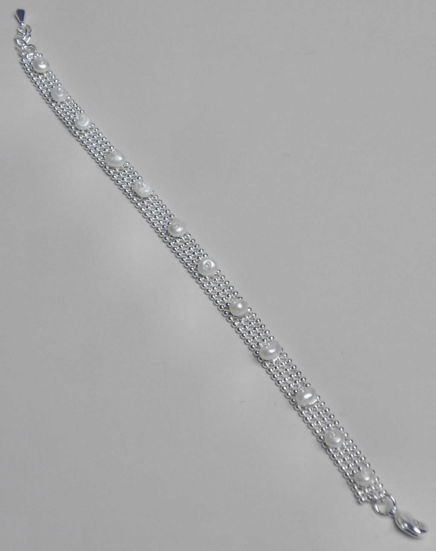 Es handelt sich um etwa 20 cm lange Armbänder aus unedlen Metallen, bestehend aus vier parallel zueinander angeordneten Reihen aus kleinen Kugeln, die mittels Stege miteinander verbundenen sind. Die Armbänder sind mit einem Karabinerhakenverschluss und einer kurzen Verlängerungskette ausgestattet und in regelmäßigen Abständen mit runden Süßwasserperlen besetzt. Die Erzeugnisse sind in einem einfachen Kunststoffbeutel verpackt.
- Antragstellerangaben - 

Abbildung siehe Anlage.

Derartige Erzeugnisse gehören als "Waren aus echten Perlen oder Zuchtperlen" zum TARIC-Code 7116 1000 00.