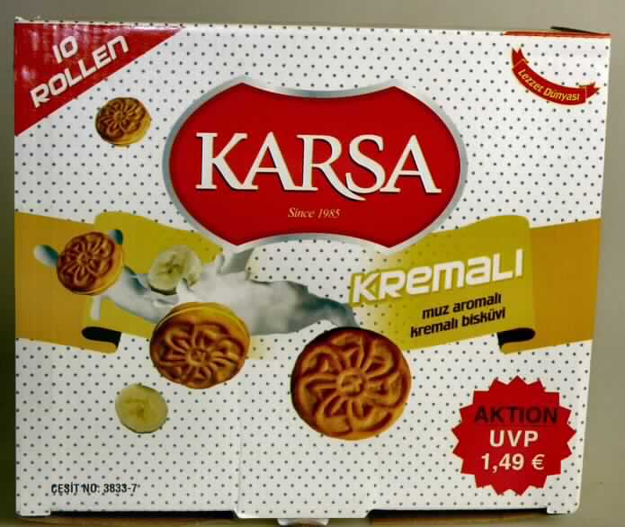 Doppelkeks mit Bananengeschmack

Vertrauliche Angaben (s. Feld 8) zur Zusammensetzung und ein Warenmuster lagen vor.

Pappschachtel mit Original-Aufdruck in überwiegend türkischer Sprache (Kremali - muz aromali kremali bisküvi), auf der Unterseite auch mehrsprachige Warenbezeichnungen (Doppelkekse mit Cremefüllung Bananengeschmack; 600 g) und Angaben zu den Zutaten. Im Inneren 10 unbedruckte weiße Schlauchfolienpackungen mit hellbraunen, mit gelber Fettcreme gefüllten Doppelkeksen (Durchmesser 3,5 cm) mit Blütenmuster, Geschmack süß und nach Keks, Fettcreme und Bananenaroma.

Wassergehalt im Keksanteil*: 12 GHT oder weniger
Fettgehalt im Keksanteil*: 35 GHT oder weniger 
Stärke/Glucose**: 25 bis weniger als 50 GHT
Saccharose/Invertzucker/Isoglucose***: 5 bis weniger als 30 GHT
Milchfett*: weniger als 1,5 GHT
Milchprotein*: weniger als 2,5 GHT

* : berechnet aus den Rezepturangaben
**: festgestellt gem. VO (EG) Nr. 900/2008, VO (EU) Nr. 118/2010
***: festgestellt gemäß VO (EG) Nr. 900/2008

Backware, Kekse gesüßt, ohne kakaohaltigen Überzug, mit einem Gehalt an Milchfett von weniger als 8 GHT, Doppelkeks