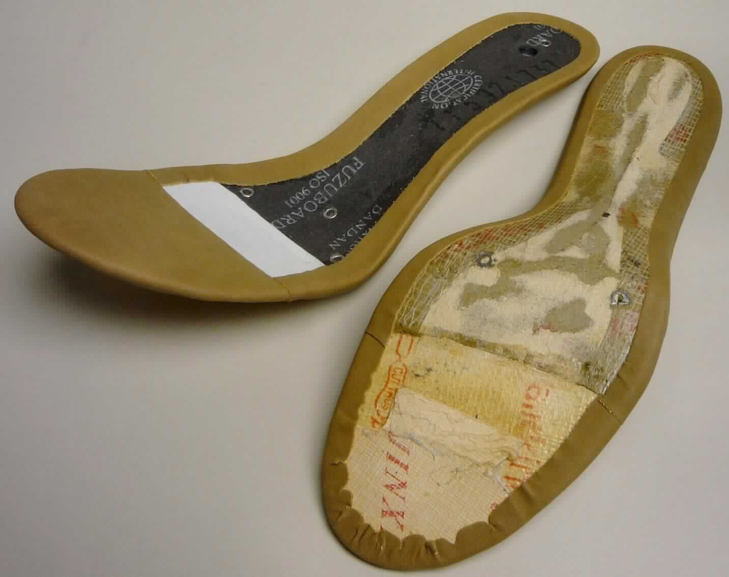 Schuhteile/Brandsohlen (lt. Antrag "2 Brandsohlen", Foto siehe Anlage)
- annähernd in der Form einer Fußsohle,
- werden in die Schuhe dauerhaft eingearbeitet (damit keine Einlegesohle),
- nicht handgearbeitet

"Schuhteile (Brandsohlen), nicht handgearbeitet"