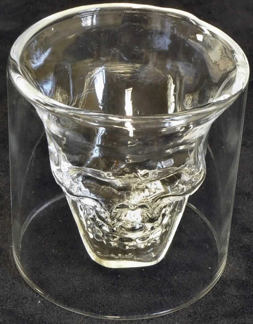 Trinkglas, sog. Schnapsglas, Foto siehe Anlage,
- zylinderförmiges Trinkglas ohne Stiel (Schnapsglas),
- mit einem inneren Glaseinsatz, der in Form eines Totenkopfs gearbeitet ist,
- aus (laut Antrag) mechanisch gefertigtem, klarsichtigem Glas,
- am oberen Rand abgerundet gearbeitet,
- weder geschliffen noch anders bearbeitet,
- mit einer Höhe von ca. 7 cm und einem Durchmesser von ca. 7 cm,
- soll zum Trinken von farbigem Schnaps verwendet werden,
- in einer zur Verpackung der Ware üblichen, bunt bedruckten Schachtel aus Pappe verpackt.

"Glasware zur Verwendung bei Tisch, Trinkglas ohne Stiel, nicht aus Glaskeramik, Bleikristall oder vorgespanntem 
 Glas, mechanisch gefertigt (mechanische Glasentnahme), weder geschliffen noch anders bearbeitet"