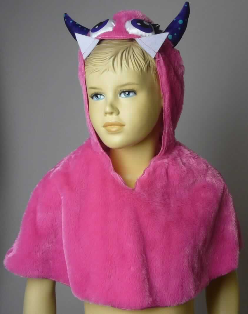 Umhangähnliches Kleidungsstück, sog. Kinder Cape Monster lila, Art. 186616, für Kinder von 2-3 Jahren (entspricht Größe 92-98), Foto siehe Anlage,
- aus einfarbigen, langflorigen Plüschgewirken aus laut Antrag 100 % Polyester (synthetische Chemiefasern),
- über die Taille reichend (Rückenlänge: ca. 30 cm); den Oberkörper, die Schultern und die Arme bedeckend,
  wird in der Art eines Überwurfs über den Schultern getragen,
- mit einer angesetzten Kapuze in der Art eines "Monsterkopfes", mit angenähten "Augen", "Hörnchen" und
  "Zähnen",
- mit einem V-förmigen, leicht halsfernen Ausschnitt,
- ohne Öffnung und ohne Verschluss,
- ohne Hinweise auf den Trägerkreis (unisex),
- ohne Ärmel oder Armöffnungen,
- an allen Rändern durch Überwendlichnähte gesäumt, 
- gehört als Maskenkostüm aus Spinnstoffen nicht zum Warenkreis der Position 9505,
- wird im Allgemeinen über jeder anderen Kleidung und zum Schutz gegen das Wetter getragen, somit keine Ware
  der Position 6307.

"Umhangähnliches Kleidungsstück, aus Gewirken, für Mädchen, aus Chemiefasern"