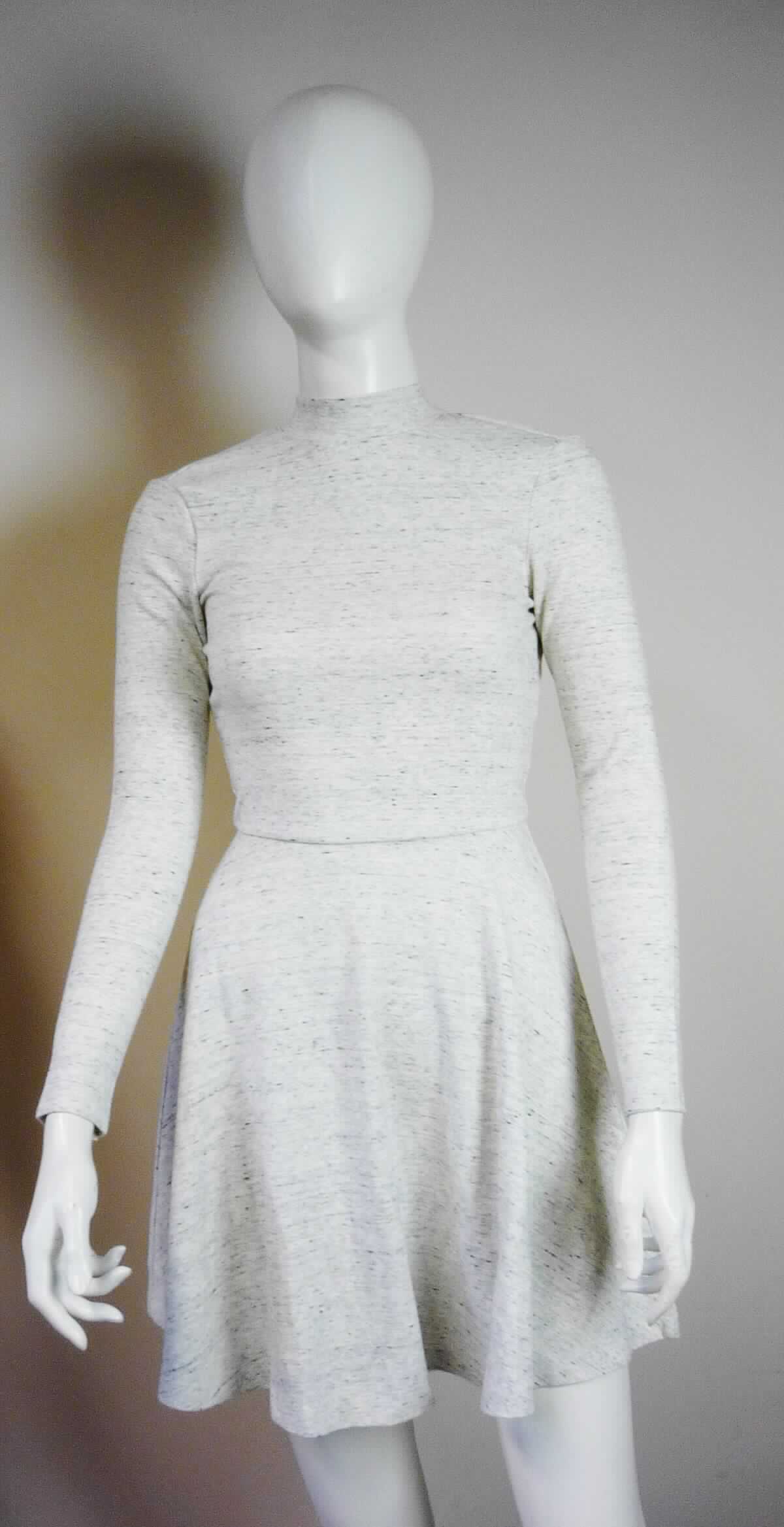 Kleid, sog. Strickkleid, Art. RSAPO3148, Größe S, Foto siehe Anlage,
- aus ca. 1 mm dicken, buntgewirkten Gewirken (melierte Garne) aus laut Antrag 79 % Viskose (künstliche 
  Chemiefasern), 6 % Polyester, 5 % Elasthan (beides synthetische Chemiefasern) und 10 % Baumwolle, 
- über den Schritt reichend (Rückenlänge: ca. 83 cm),
- mit einem schmalen Stehkragen,
- hinten mit einer kurzen Öffnung mit Knopfverschluss am oberen Rand,
- mit langen Ärmeln,
- im Rückenbereich mit einer ca. 38 cm langen Aussparung,
- am unteren Rand durch Umschlagen und Festnähen gesäumt,
- kann aufgrund der Länge ohne ein weiteres, den Unterkörper bedeckendes Kleidungsstück getragen werden.

"Kleid, aus Gewirken, für Frauen, aus künstlichen Chemiefasern"