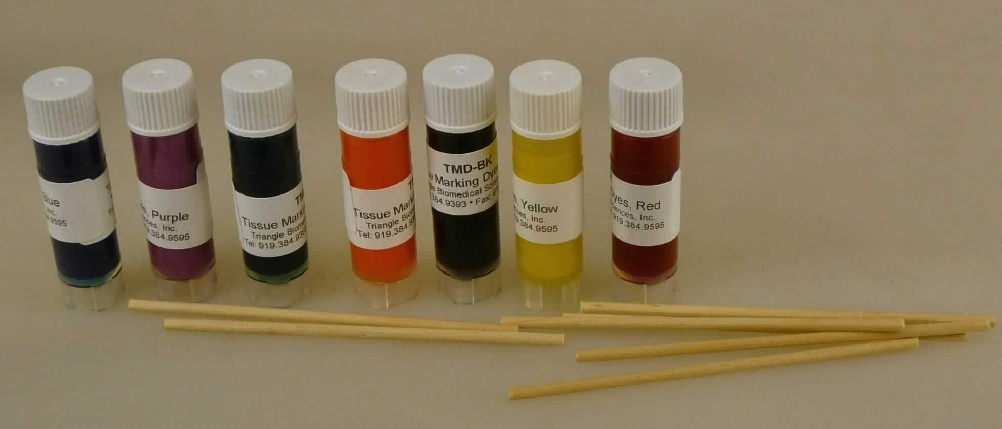 Angaben: TMD - Tissue Marking Dye (Gewebemarkierungsfarben); siebenteilige Zusammenstellung bestehend aus einem Holzklotz mit 7 Bohrungen (zur sicheren Aufbewahrung der Flaschen), einigen Holzstäbchen (zum Auftragen der Lösungen) und sieben zubereiteten Lösungen in unterschiedlichen Farben (rot, schwarz, blau, grün, gelb, lila, orange), jeweils abgefüllt in 60ml-Plastikflaschen; zum Anfärben von Gewebeproben (menschlichen oder tierischen Ursprungs) für mikroskopische Untersuchungen im Labor (Krebsdiagnostik).
 
Befund: Färbemittel, in Formen oder Packungen für den Einzelverkauf