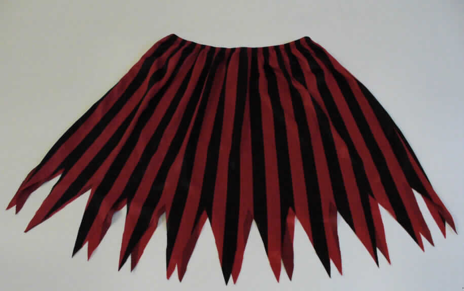 Vierteilige Zusammenstellung, bestehend aus einer Bluse, einem Rock, einem Bekleidungszubehör
aus Kunststoff (Gürtel) und einem Bekleidungszubehör aus Gewirken (Haarband), sog. Piratenkostüm
für Kinder, in Kindergröße, Fotos siehe Anlage,
- gemeinsam in einem Polybeutel mit bedrucktem Pappeinleger für den Einzelverkauf aufgemacht, 
- gehört als Maskenkostüm aus Spinnstoffen nicht zum Warenkreis der Position 9505,
- getrennte Einreihung aller Bestandteile, weil die Kleidungsstücke nicht zusammen in eine Position 
  eingereiht werden können,
- alle Flächenerzeugnisse aus laut Antrag 100 % Polyester (synthetische Chemiefasern),
- Rock:
-- aus ca. 0,3 mm dicken, bedruckten Gewirken,
-- bis über den Schritt reichend, am unteren Rand zackenförmig gearbeitet (Länge: 33 bis 45 cm),
-- in der Taille abschließend, mit einem elastischen Taillenbund,
-- ohne Öffnung und ohne Verschluss.

"Rock, aus Gewirken, für Mädchen, aus synthetischen Chemiefasern"