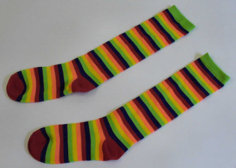 Dreiteilige Zusammenstellung, bestehend aus einem Kleid, einer langen Hose und einem Paar Kniestrümpfe,
sog. Clownkostüm für Erwachsene, Größe S, Fotos siehe Anlage, 
- gemeinsam in einem Polybeuel mit bedrucktem Pappeinleger für den Einzelverkauf aufgemacht, 
- gehört als Maskenkostüm aus Spinnstoffen nicht zum Warenkreis der Position 9505,
- getrennte Einreihung aller Bestandteile, weil die Kleidungsstücke nicht zusammen eingereiht 
  werden können,
- alle Flächenerzeugnisse aus laut Antrag 100 % Polyester (synthetische Chemiefasern), 
- Kniestrümpfe:
-- aus ca. 1,3 mm dicken, buntgewirkten Gewirken,
-- schlauchförmig gewirkt und an den Fußspitzen durch Zusammennähen konfektioniert,
-- mit ausgearbeiteter Ferse,
-- bis über die Mitte der Waden reichend, 
-- am oberen Rand mit einem ca. 2 cm breiten, elastischen Abschluss.

"Kniestrümpfe, aus Gewirken, andere als in den Unterpositionen 6115 10 und 6115 30 genannte,
 aus synthetischen Chemiefasern"