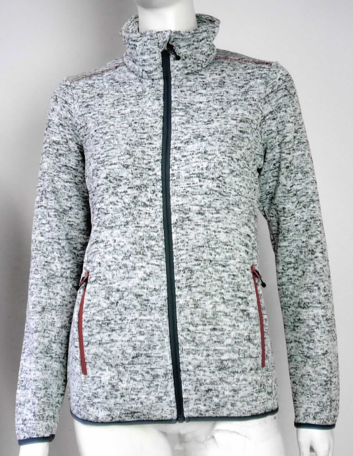 Blouson, sog. Strickjacke, Damen Strickfleecejacke, Größe 34, Foto siehe Anlage,
- aus ca. 1,9 mm dicken, einseitig (Innenseite) gerauten, buntgewirkten Gewirken (melierte Garne) aus laut 
  Antrag 100 % Polyester (synthetische Chemiefasern),
- über die Taille reichend (Rückenlänge: ca. 62 cm),
- mit einem Stehkragen,
- vorn mit einer durchgehenden Öffnung mit einem bis in die Kragenspitzen reichenden Reißverschluss, am 
  Kragenrand mit einer kurzen Überlappung von rechts auf links (Frauenkleidung),
- mit langen Ärmeln, die über den unteren Rand des Kleidungsstücks hinausreichen; an den Ärmelenden
  elastisch verengt,
- mit zwei eingesetzten Taschen mit Reißverschluss unterhalb der Taille,
- am unteren Rand mit einem schmalen, elastischen Gewebeband eingefasst und leicht verengt,
- erfüllt die Merkmale zur Einreihung als Blouson, somit keine Jacke oder Strickjacke.

"Blouson, aus Gewirken, für Frauen, aus Chemiefasern"