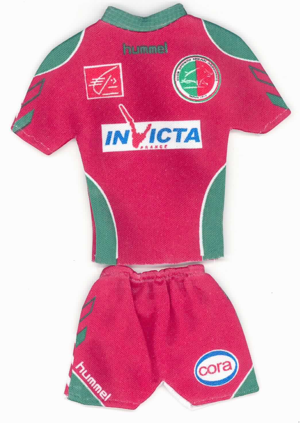 Bei dem sog. Mini-Kit in Form eines Mini-Fußballtriko-Sets handelt es sich um ein auf Vorder- und Rückseite unterschiedlich gestaltetes zweiteiliges Bekleidungs-Set für Puppen, bestehend aus einem T-Shirt-ähnlichen Oberteil und einer dazu passenden kurzen Hose. Die Bekleidungsstücke sind, wie beim Fußball üblich, mit Aufdruck des Vereins und Werbung der Sponsoren versehen. Das Oberteil ist ca. 15 cm lang und besitzt einen offenen runden Ausschnitt. Die Hose besitzt ein Gummizugbündchen. Arm-, Bein-, Kopf- und Rumpfausschnitte lassen das Bekleiden einer Puppe zu.
Das Set ist auf einer körperähnlichen Kartonage mit einem Saugnapf in einem Polybeutel mit Pappaufhänger für den Einzelverkauf aufgemacht. 

Die Ware ist als "Puppenzubehör, erkennbar hauptsächlich für Puppen, nur Nachbildungen von Menschen darstellend" einzureihen.

Anlage: 1 Abbildung