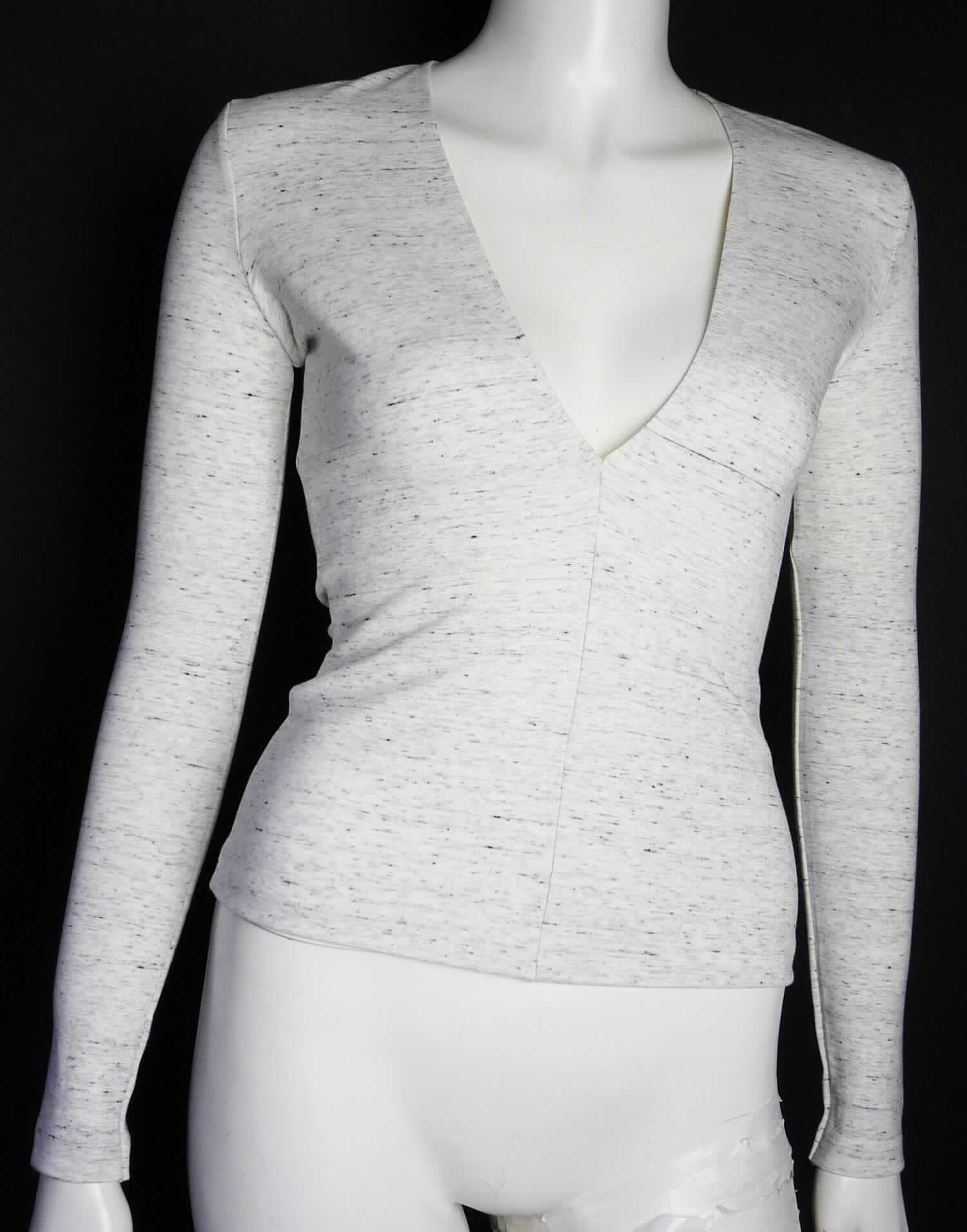 Bluse, sog. Strick T-Shirt, Artikelnummer RSAPO3155, Größe S, Foto siehe Anlage,
- aus 0,8 mm dicken (leichten), buntgewirkten Gewirken (melierte Garne) aus laut Antrag 79 % Viskose, 
  5 % Elasthan und 6 % Polyester (alles Chemiefasern) sowie 10 % Baumwolle; mit durchschnittlich mehr 
  als 10 Maschen in jeder Richtung je linearen Zentimeter,
- über die Taille reichend (Rückenlänge: ca. 52 cm),
- mit einem V-förmigen, sehr tiefen Halsausschnitt (deshalb keine Ware der Position 6109),
- ohne Öffnung und ohne Verschluss; ohne Hinweise auf den Trägerkreis (unisex), 
- mit langen Ärmeln, an den Ärmelenden gesäumt,
- am unteren Rand durch Umschlagen und Festnähen gesäumt.

"Bluse, aus Gewirken, für Frauen, aus Chemiefasern"