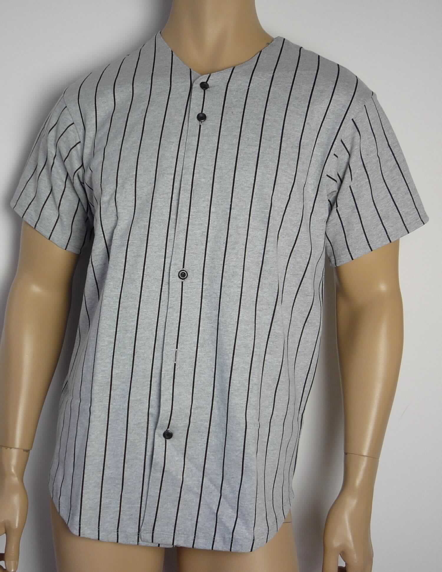 Hemd, sog. Strick Baseball Tee, Artikelnummer RSA1403P, Größe XS, Foto siehe Anlage,
- aus ca. 0,7 mm dicken, buntbedruckten Gewirken aus laut Antrag 90 % Baumwolle und 10 % Polyester 
  (synthetische Chemiefasern); mit durchschnittlich 9 Maschen in horizontaler und 15 Maschen in vertikaler
  Richtung je linearen Zentimeter,
- über die Taille reichend (Rückenlänge: ca. 75 cm),
- mit einem V-förmigen Halsausschnitt,
- vorn mit einer durchgehenden Öffnung mit Knopfverschluss von links auf rechts (Männerkleidung),
- mit kurzen Ärmeln, an den Ärmelenden gesäumt,
- am unteren Rand abgerundet gearbeitet und durch Umschlagen und Festnähen gesäumt.

"Hemd, aus Gewirken, für Männer, aus synthetischen Chemiefasern"