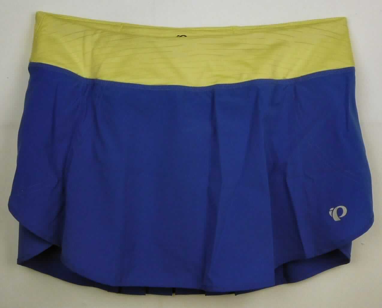 Rock, sog. W Fly Run Skirt, Art. 12211405, Größe M, Foto siehe Anlage,
- aus ca. 0,2 mm dicken, einfarbigen Geweben aus lt. Antrag 100 % Polyester und im Bereich des Taillenbunds 
  aus ca. 0,8 mm dicken, einfarbigen, strukturiert gewirkten Gewirken aus lt. Antrag 92 % Polyester und 8 % 
  Elasthan (beides synthetische Chemiefasern) ,
- in der Taille abschließend, mit einem elastischen Taillenbund mit Tunnelzug,
- hinten im Taillenbund mit einer eingesetzten Tasche mit Reißverschluss,
- Vorder- und Rückseite überlappen sich seitlich, sind jedoch nur bis zu 14 cm vom Bund ausgehend
  miteinander verbunden,
- ohne Öffnung und ohne Verschluss,
- mit einem eingenähten Innenslip,
- über den Schritt reichend (Seitenlänge: ca. 30 cm),
- am unteren Rand mit einer Randeinfassung aus Geweben und zu den ca. 11 cm hoch reichenden Seitenschlitzen 
  hin abgerundet gearbeitet,
- die Gewebe verleihen der Ware insbesondere im Hinblick auf den Umfang ihren wesentlichen Charakter.

"Rock, aus Geweben, für Frauen, aus synthetischen Chemiefasern, nicht nach dem Batik-Verfahren handbedruckt"