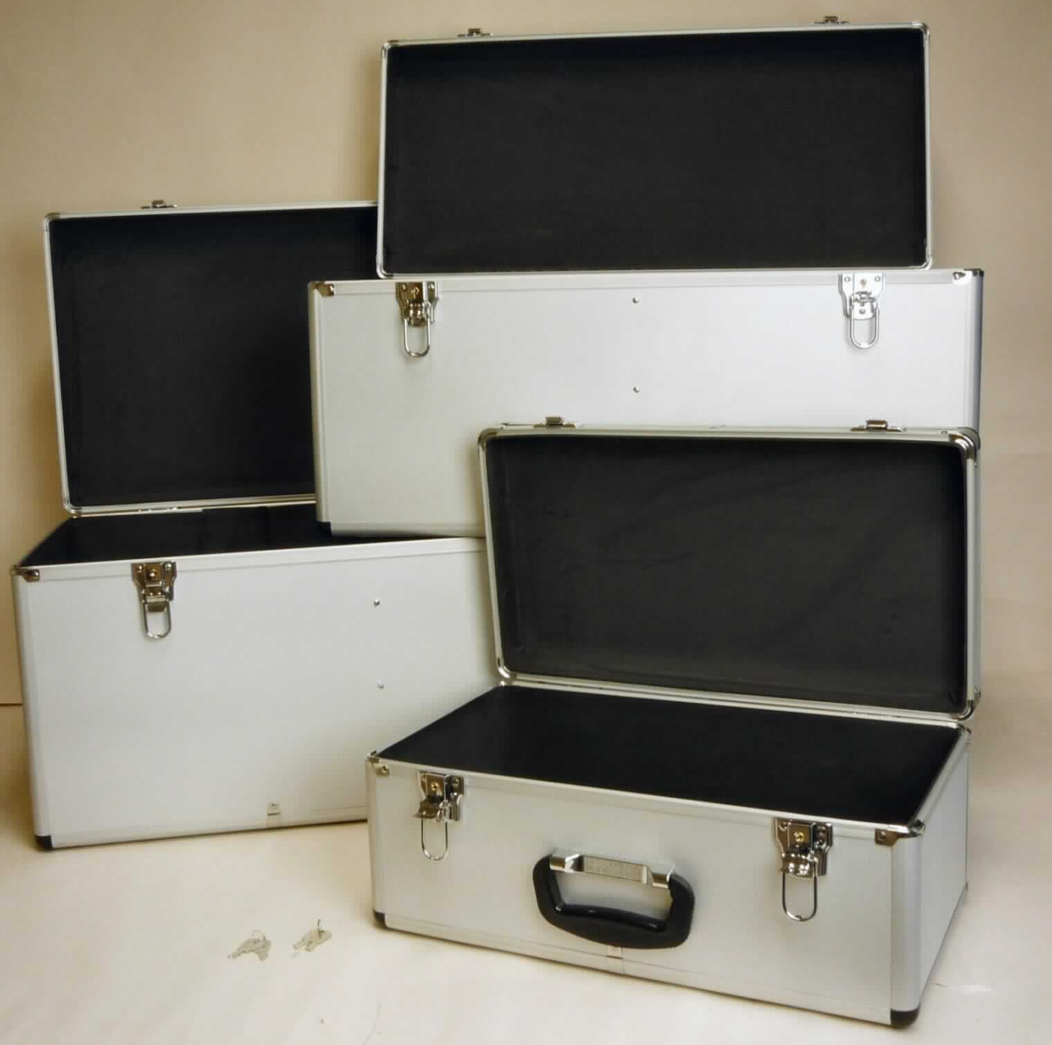 Zusammenstellung aus drei handkofferähnlichen Behältnissen, Foto siehe Anlage,
-  in Aufmachung für den Einzelverkauf (ineinander verpackt),
-  keine Warenzusammenstellung, da alle Waren in die gleiche Unterposition eingereiht werden,
- mit einer Außenseite aus silberfarbenen Kunststofffolien (strukturiert), die auf einer 
  Unterkonstruktion aus entsprechend zugeschnittenen Holzfaserplatten aufgeklebt sind,
- mit einem Rahmen aus Aluminium und Eckverstärkungen aus Kunststoff,
- in den Abmessungen: 
- - kleiner Koffer: 47,5 cm x 26 cm x 21 cm,
- - mittlerer Koffer: 68 cm x 31 cm x 32 cm,
- - großer Koffer: 73 cm x 38 cm x 36 cm,
- mit einem Handtragegriff aus Kunststoff,
- mit zwei verschließbaren Bügelschlössern aus unedlem Metall,
- - innen ohne weitere Einteilung; mit Schaumkunststoff ausgekleidet.

"Handkofferähnliche Behältnisse, mit Außenseite aus Kunststofffolien"
