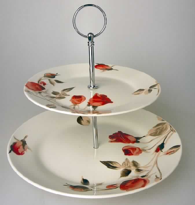 Haushaltsartikel zum Tischgebrauch, sog. Etagere, Foto siehe Anlage,
- aus verschiedenen Stoffen zusammengesetzte Ware in Form einer Etagere mit einer Höhe 
  von ca. 25 cm, bestehend
- - aus Porzellan in Form von zwei glasierten, runden Tellern mit leicht erhöhtem Rand,
- - - mit einem Rosen darstellenden Motiv bunt bedruckt,
- - - mit einem Durchmesser von ca. 26 cm bzw. 19 cm,
- - - in der Mitte jeweils mit einer runden Aussparung versehen,
- - - keramische Erzeugnisse, nach der Formgebung gebrannt, tonmineralhaltiges Material
      enthaltend,
- - - aus (laut Antrag) Porzellan,
- - aus unedlem Metall in Form einer zweiteiligen, zusammenschraubbaren Halterung,
- - - die Halterung dient dem Aufstellen der Teller in einem Abstand von ca. 10 cm,
- - - die Halterung ist am oberen Ende mit einem runden Ring versehen,
- das Porzellan bestimmt nach dem Umfang und seiner Bedeutung in Bezug auf die
  Verwendung den wesentlichen Charakter der zusammengesetzten Ware,
- zur Verwendung als Etagere zum Tischgebrauch (z.B. für Gebäck) vorgesehen.

"Haushaltsartikel für den Tischgebrauch, aus Porzellan"