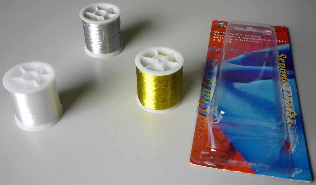 Sog. Nähgarn, Art. 1327, Foto siehe Anlage,
- Warenzusammenstellung, bestehend aus zwei metallisierten Garnen und einem synthetischen Monofil,
- laut Antrag gemeinsam in einer Blisterverpackung für den Einzelverkauf aufgemacht und zur Befriedigung 
  eines speziellen Bedarfs zusammengestellt,
- als Meterware, jeweils auf einer Rolle aus Kunststoff aufgewickelt,
- metallisierte Garne:
-- mit einer Breite von ca. 0,1 mm,
-- laut Untersuchungsergebnis aus einem Garn aus Spinnstoffen, das mit einem metallisierten Streifen aus 
   synthetischer Spinnmasse (laut Antrag aus 100 % Polyester) umwickelt ist,
- synthetisches Monofil:
-- mit einer Breite von ca. 0,1 mm,
-- laut Antrag aus 100 % Nylon (synthetische Chemiefasern),
-- laut Untersuchungsergebnis mit einem Titer von ca. 155 detx,
-- ungezwirnt,
-- kein Elastomer,
- insbesondere im Hinblick auf die Menge bestimmen die metallisierten Garne den Charakter der 
  Warenzusammenstellung, somit keine Ware der Position 5508.

"Metallisierte Garne, bestehend aus Garnen aus Spinnstoffen, in Verbindung mit Metall in Form von Streifen"